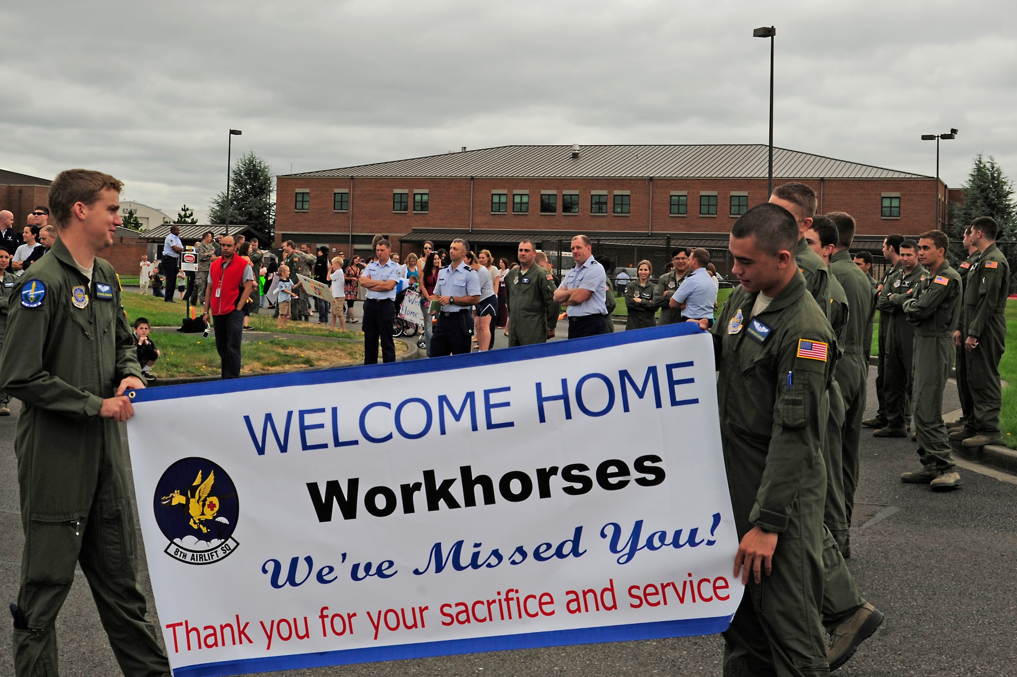 Friends and family members wait for Airmen of the 8th Airlift Squadron to return from a 75-day deployment July 30, 2012, at Joint Base Lewis-McChord, Wash. During their deployment, the C-17 squadron flew 635 sorties, equaling more than 1,500 hours, moved more than 45,500 passengers and delivered more than 19 million pounds of combat sustainment cargo for U.S. military forces in and out of the U.S. Central Command area of operations. (U.S. Air Force photo/Adamarie Lewis-Page)