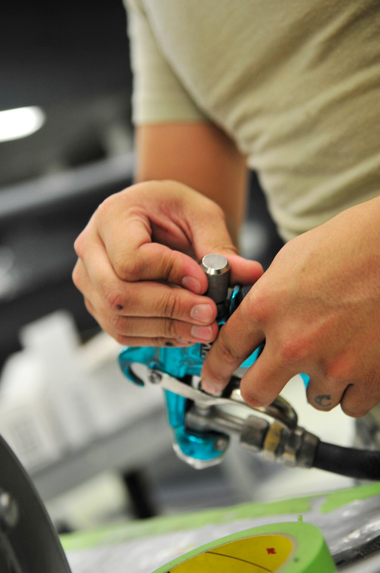 U.S. Air Force Staff Sgt. Shon Nguyen, 20th Equipment Maintenance Squadron aircraft equipment specialist, prepares a paint gun for the painting of an F-111 "Aardvark" at Shaw Air Force Base, S.C., July 27, 2012.  The  F-111 was to assigned to the 20th Fighter wing from 1970 to 1993.  It flew on 21 missions during Operation Desert Storm and will now be on display as a static aircraft here at Shaw.(U.S. Air Force photo by Airman Nicole Sikorski/Released) 
