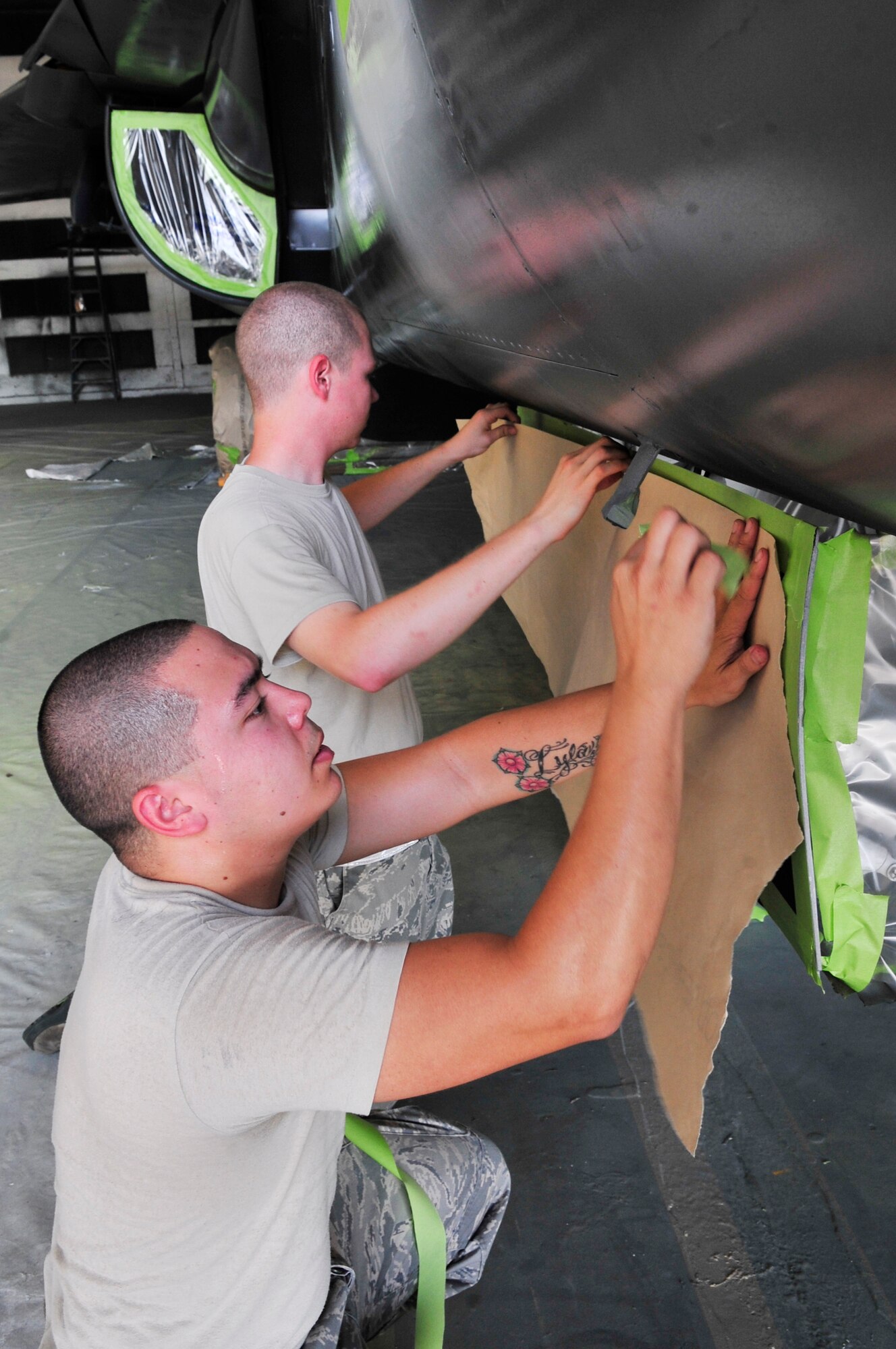 U.S. Air Force Airman 1st Class Zach Sherman, 20th Equipment Maintenance Squadron aircraft structural equipment journeyman,(back), and Staff Sgt. Shon Nguyen, 20th EMS aircraft equipment specialist, (front)  put masking tape on the F-111 "Aardvark" at Shaw Air Force Base, S.C., July 27, 2012.  The  F-111 was assigned to the 20th Fighter wing from 1970 to 1993.  It flew on 21 missions during Operation Desert Storm and will now be on display as a static aircraft here at Shaw.(U.S. Air Force photo by Airman Nicole Sikorski/Released) 