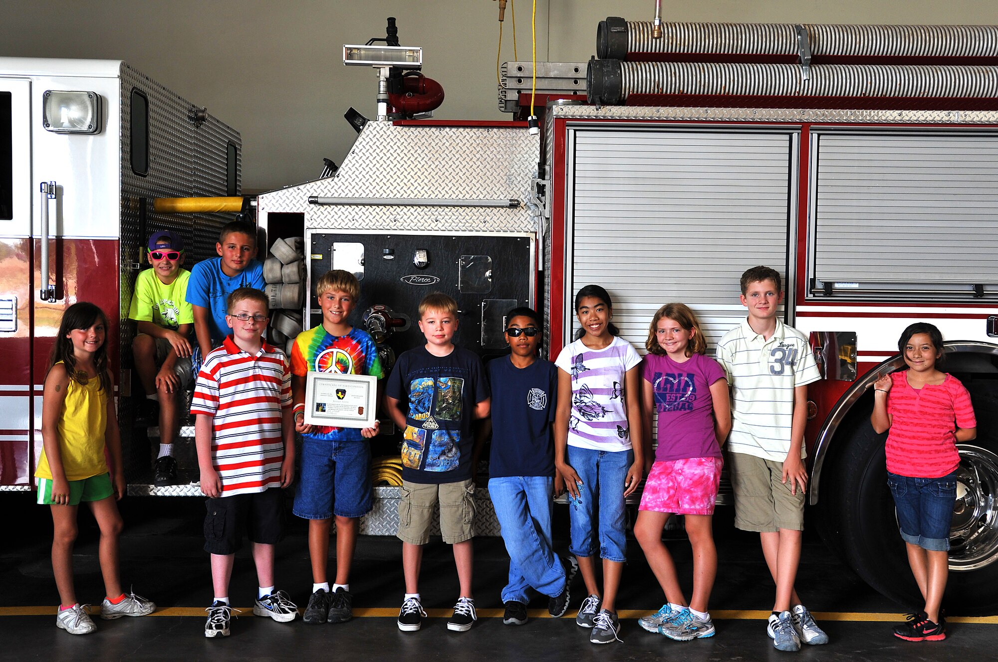 GOODFELLOW AIR FORCE BASE, Texas—Junior Firefighter Camp participants pose in front of a fire truck after their graduation July 23. The camp gives children the opportunity to learn life saving skills for medical and fire emergencies. (U.S. Air Force photo/Airman 1st Class Michael Smith)