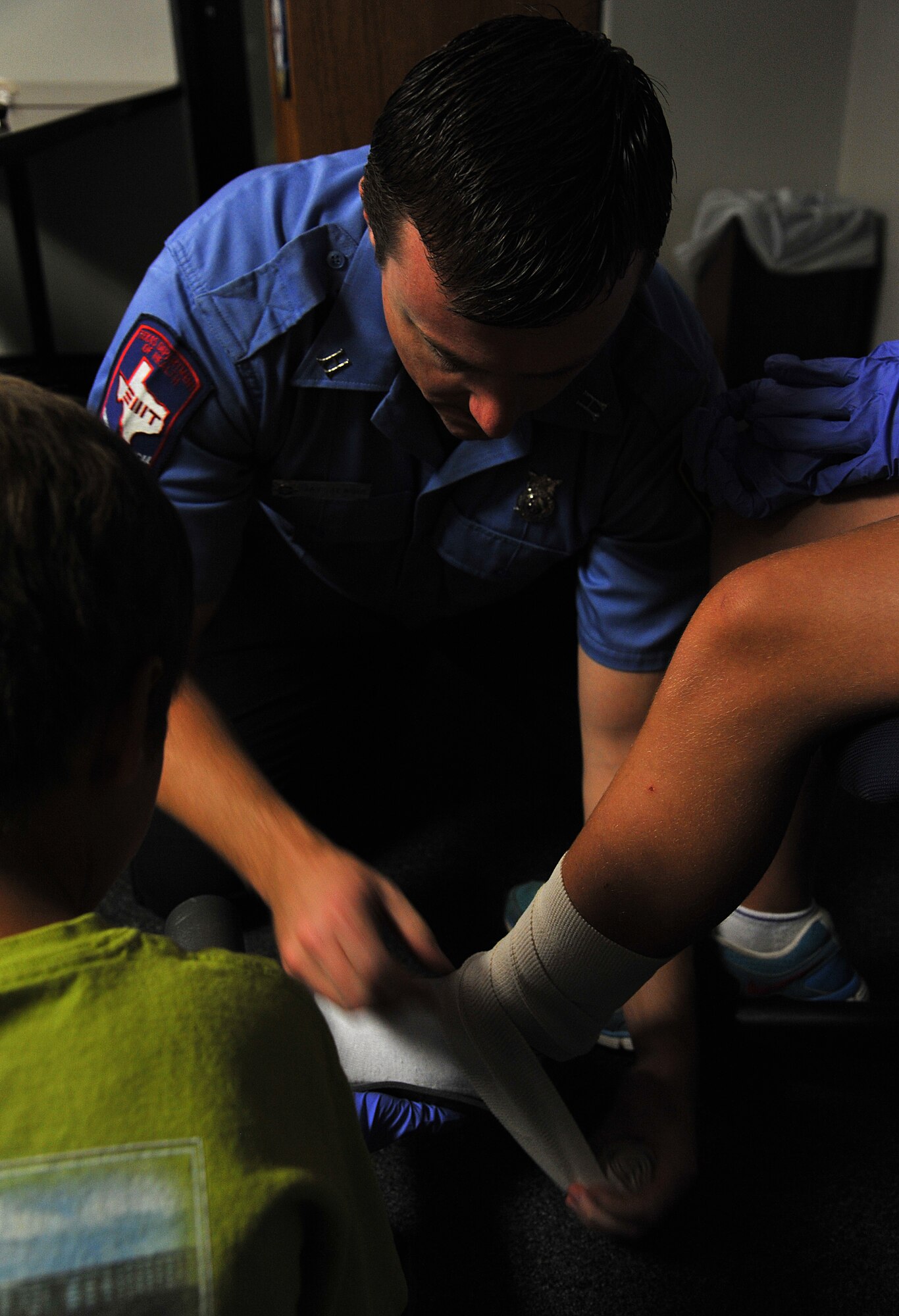 GOODFELLOW AIR FORCE BASE, Texas-- Jay Teague, 17th Civil Engineer Squadron firefighter, demonstrates how to wrap a sprained ankle to the Junior Firefighter Camp children July 23. The camp gives children the opportunity to learn life saving skills for medical and fire emergencies. (U.S. Air Force photo/Airman 1st Class Michael Smith)