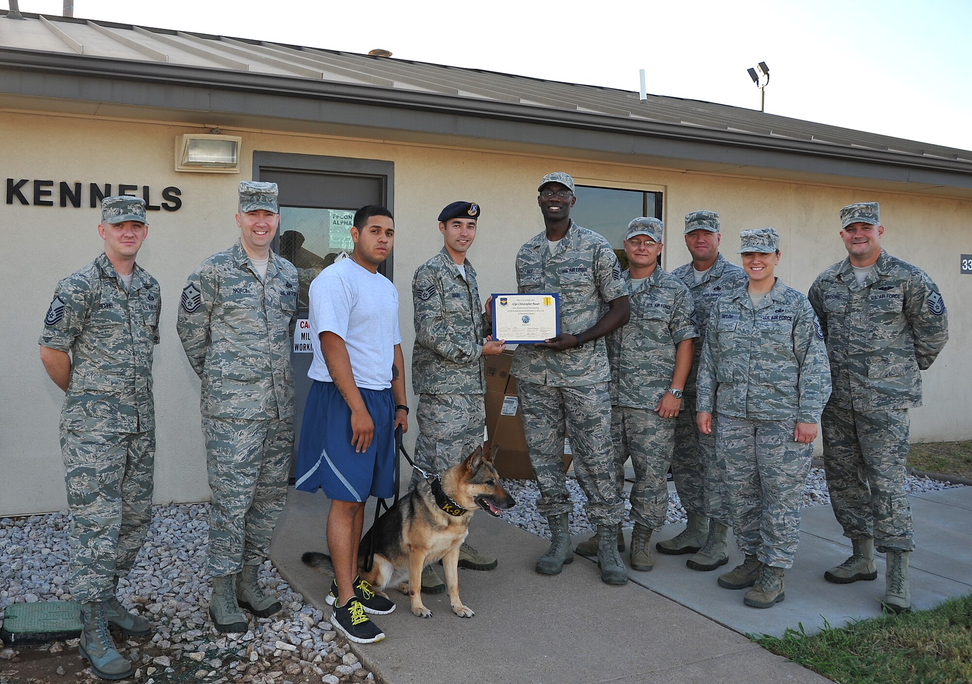 GOODFELLOW AIR FORCE BASE, Texas-- Members of the First Sergeants Council present Staff Sgt. Christopher Bauer, 17th Security Forces Squadron dog handler, with the Diamond Sharp Award June 1st. Bauer received the award for demonstrating outstanding professionalism and dedication to his work by cutting the standard training time in half for the military work dogs. (U.S. Air Force photo/Airman 1st Class Michael Smith)