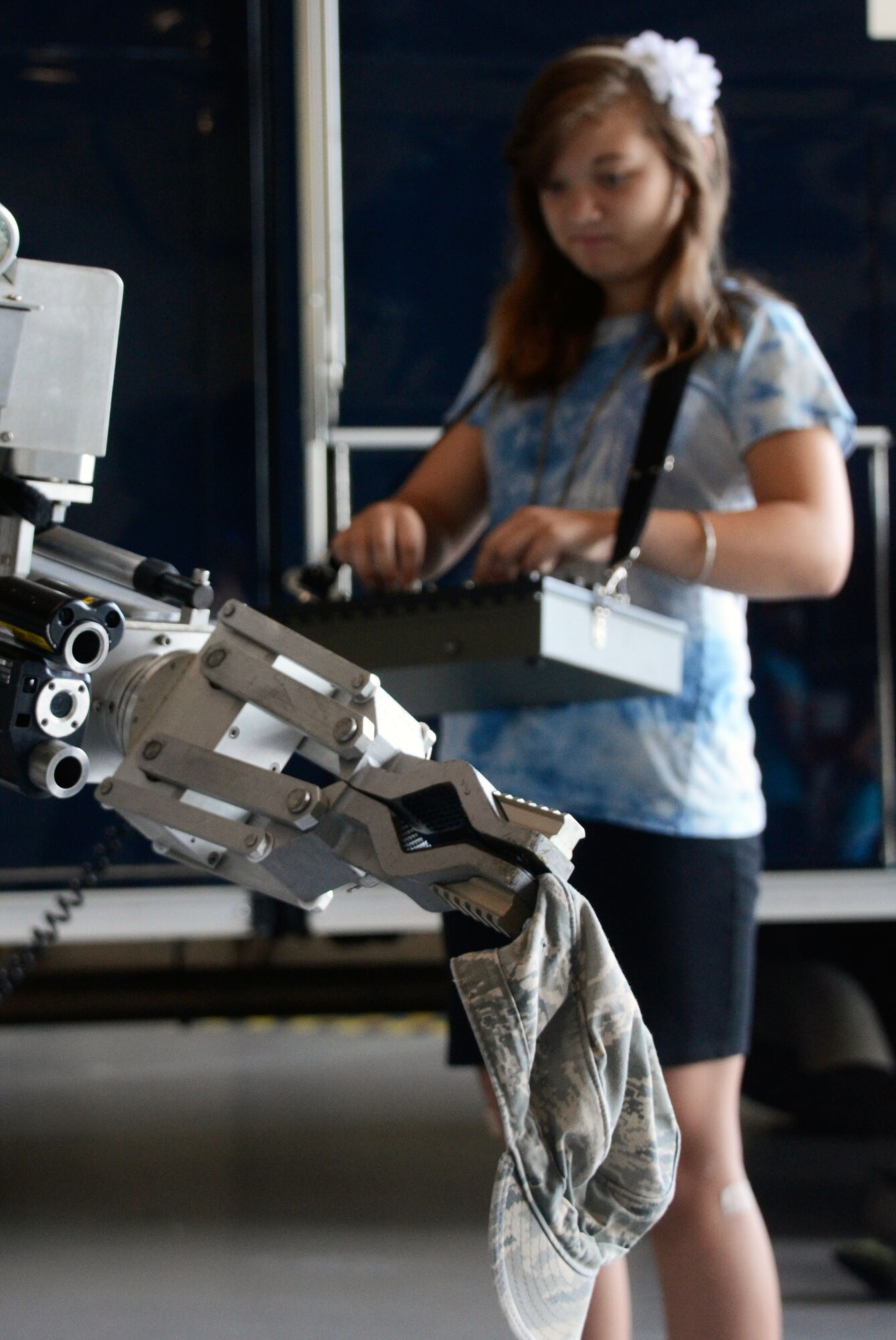 Sierra Rose, daughter of Gina Rose, of 94th Civil Engineering Squadron Environmental Flight, tries her hand at operating the Explosive Ordnance Disposal Flight’s bomb disposal robot during Bring Your Kids to Work Day July 27. Personnel were able to bring their kids to work centers and then to a hangar for hands-on experience at displays fire department, explosive ordnance and security forces as well as a C-130 simulator demonstration. (U.S. Air Force photo/Don Peek)