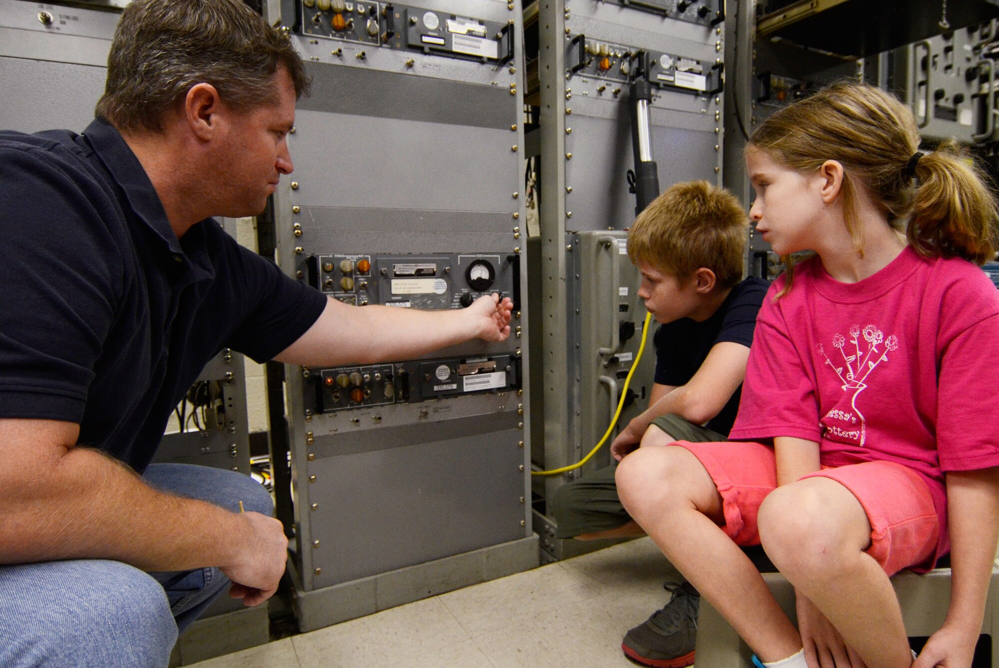 Scott Baum, an Airfield Systems Technician from the 94th Communications Squadron, shows his son Bradin and daughter Morgan around his work center during Bring Your Kids to Work Day at Dobbins Air Reserve Base, Ga., July 27. Personnel were able to bring their kids to work centers and then to a hangar for hands-on experience at displays fire department, explosive ordnance and security forces as well as a C-130 simulator demonstration. (U.S. Air Force photo/Don Peek)