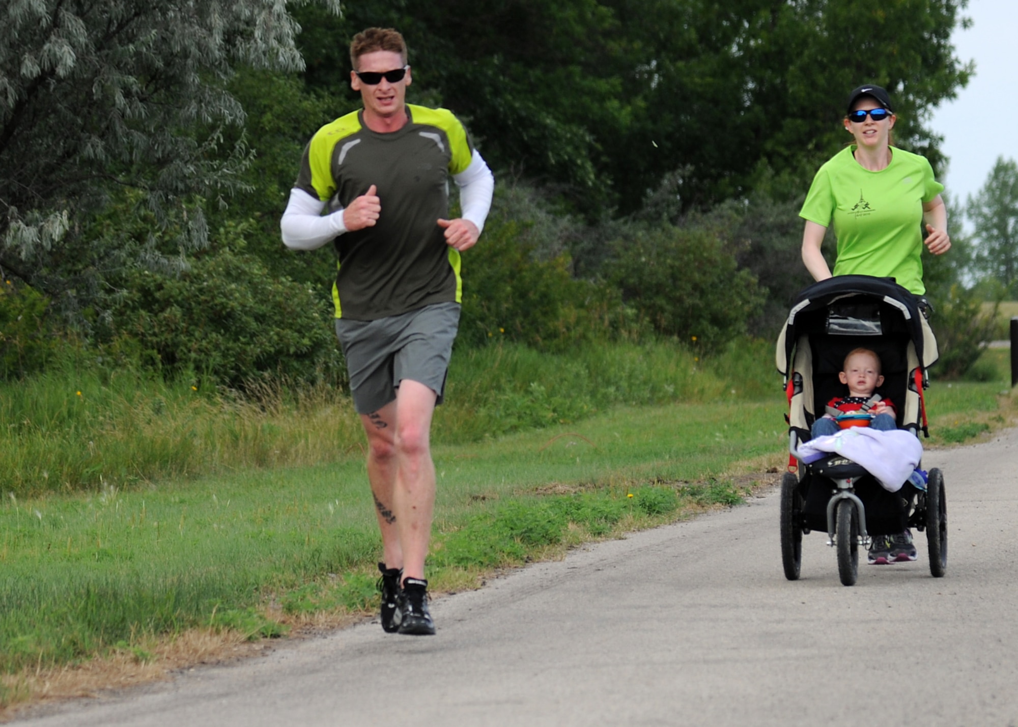 Staff Sgt. Forrest Sturman, 69th Maintenance Squadron, runs with his wife, Amanda Knight, and 19-month-old daughter, Olivia Sturman, during the 2012 Grand Forks Air Force Base Triathlon on July 28, 2012, on Grand Forks Air Force Base, N.D.  Twenty-one individuals and five teams competed in the event. (U.S. Air Force photo/Airman 1st Class Ashley N. Taylor)  