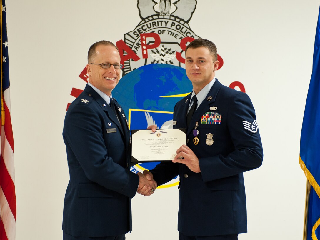 Col. Mark Weatherington, 28th Bomb Wing commander, presents Staff Sgt. Leonard Pritchett, 28th Security Forces Squadron security forces leader, with The Purple Heart at Ellsworth Air Force Base, S.D., July 27, 2012. Pritchett received the medal for wounds he received in action while deployed to Bagram Air Base, Afghanistan. (U.S. Air Force photo by Airman 1st Class Alystria Maurer/Released)