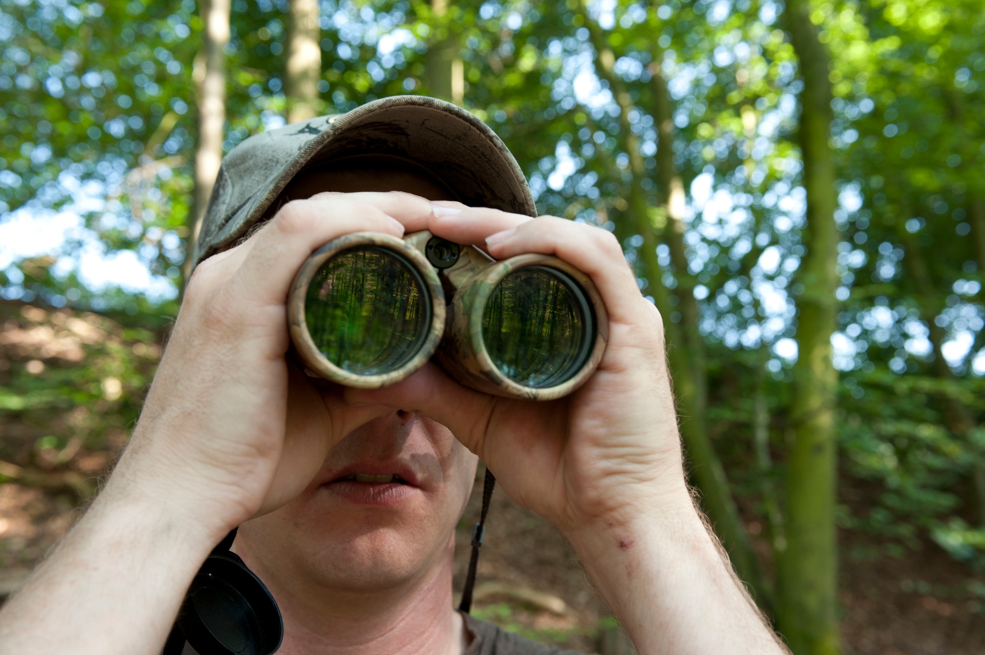 DAHLEM, Germany -- Tech. Sgt. Kevin Phillips, 52nd Equipment Maintenance Squadron aircraft structural maintainer, looks through binoculars to find the center of 3-D targets at the Eifel Bow Hunting Club July 26 here. Phillips is an amateur archer who is competing to become a professional at the European 5 Nations Field Series tournament in Ash, Luxembourg, this year. He trains with local archers with whom he builds partnerships through exchanging archery techniques. (U.S.  Air Force photo by Senior Airman Natasha Stannard/Released)