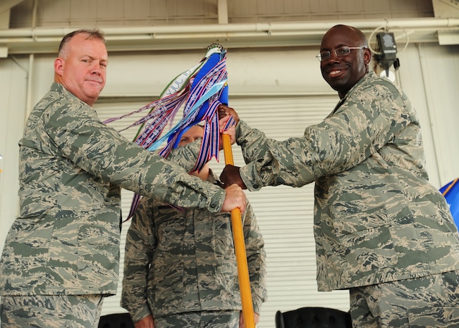 Colonel Erik Hansen, 437th Airlift Wing commander, passes the 437th Maintenance Group guidon to Col. Dennis Dabney, incoming 437th MG commander, during the 437th MXG Change of Command ceremony, July 27, 2012, at Joint Base Charleston - Air Base, S.C. The passing of the guidon symbolizes the changing of a command. (U.S. Air Force photo/ Staff Sgt. Katie Gieratz)