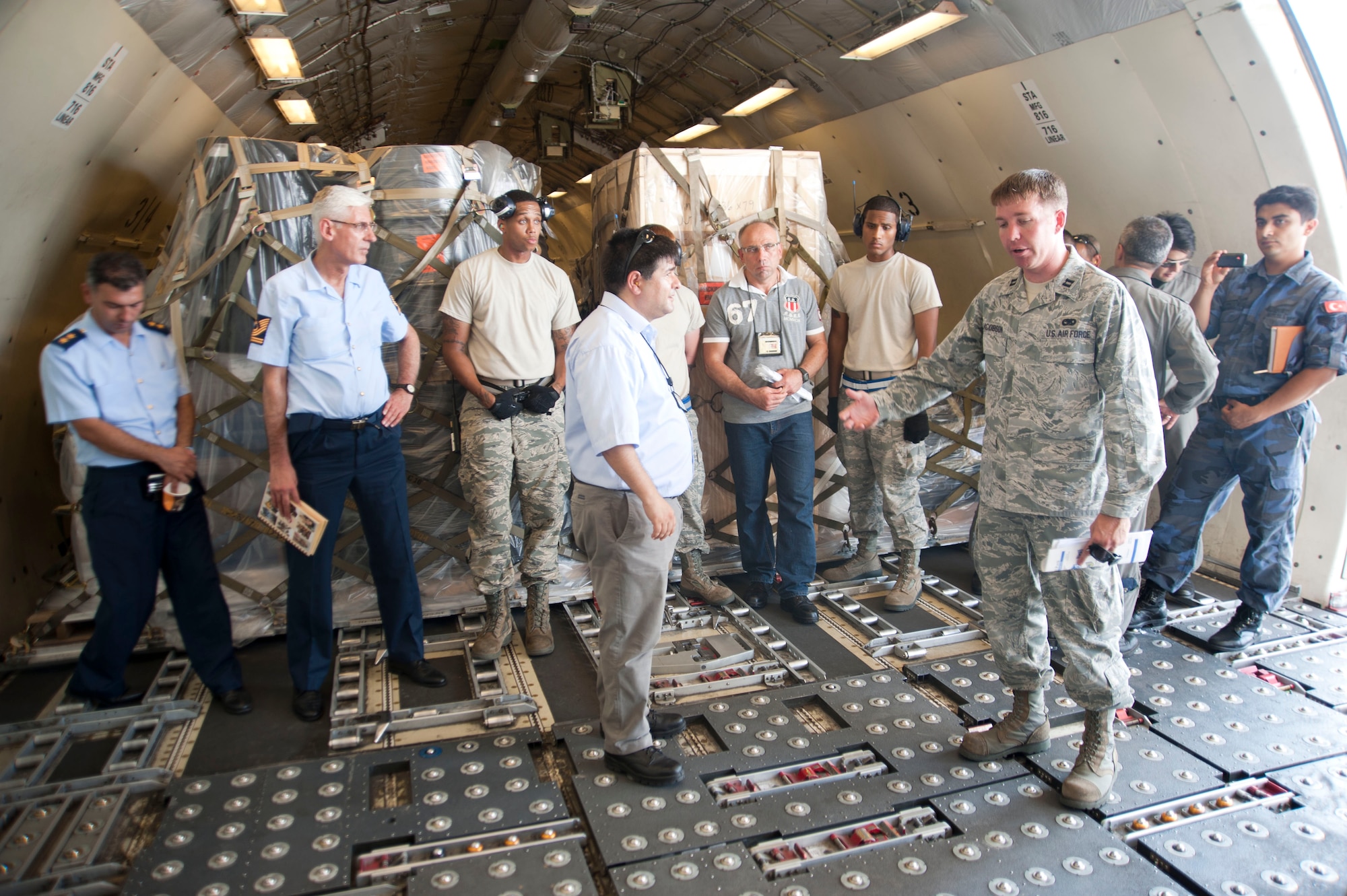 Capt. Christopher Jacobson, 728th Air Mobility Squadron, explains the function of rollers on the floor of an aircraft to members of the Turkish air force during a site visit July 25, 2012, at Incirlik Air Base, Turkey. The 728th AMS hosted the visit to help members of the Turkish air force 11th Tanker Command enhance their aerial port operations. (U.S. Air Force photo by Senior Airman Clayton Lenhardt/Released)