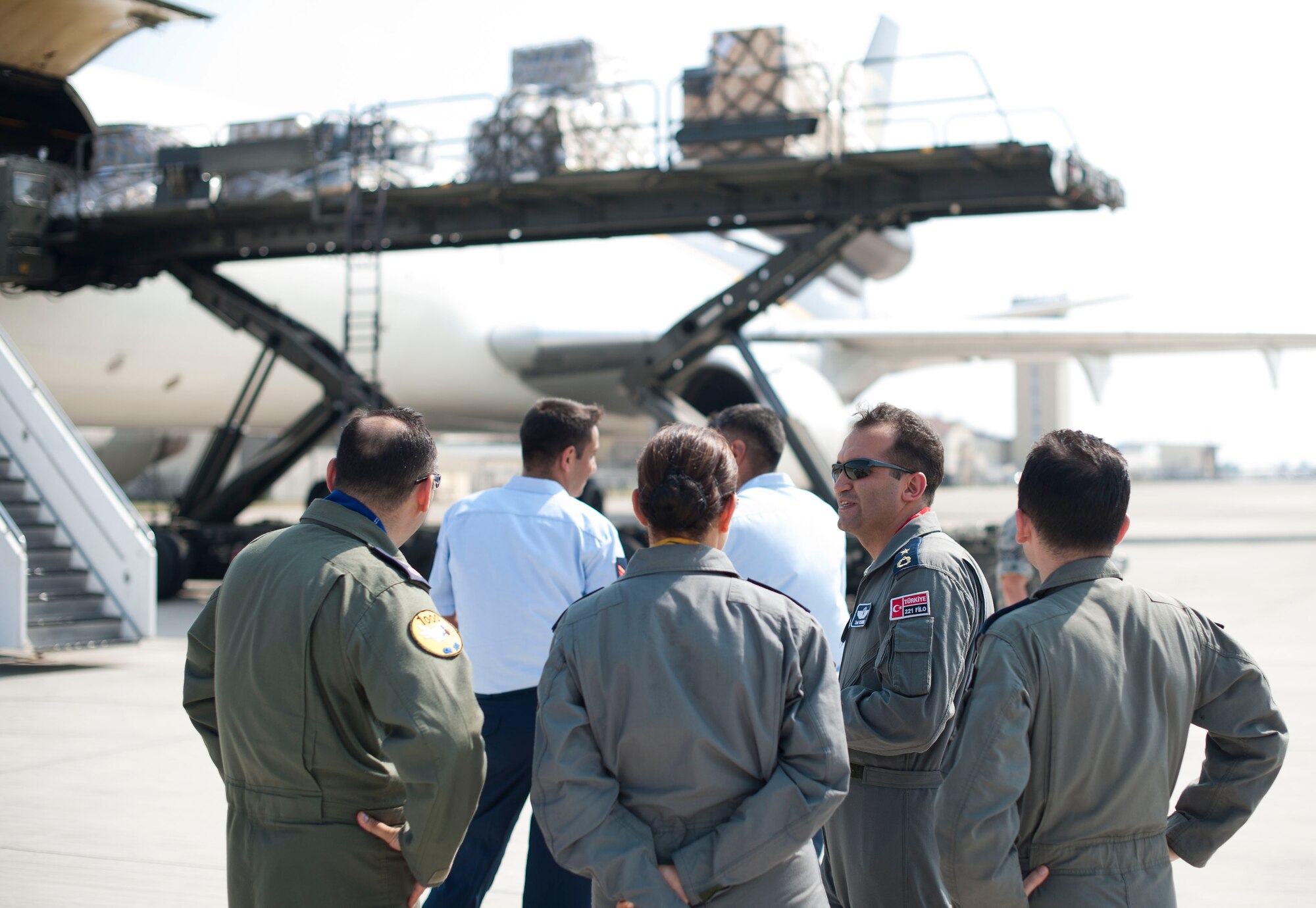 Members of the Turkish air force observe cargo downloading during a site visit July 25, 2012, at Incirlik Air Base, Turkey. The 728th Air Mobility Squadron hosted the visit to help members of the Turkish air force 11th Tanker Command enhance their aerial port operations. (U.S. Air Force photo by Senior Airman Clayton Lenhardt/Released)
