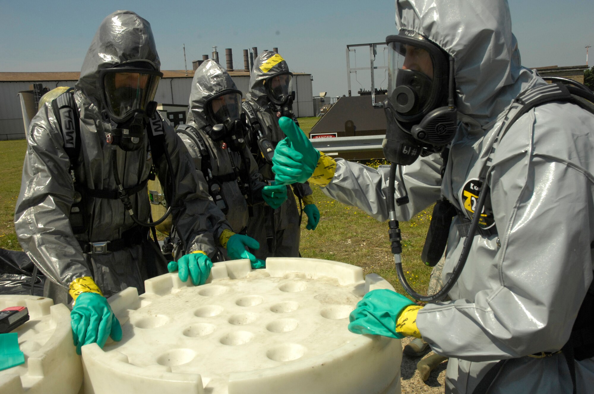 ROYAL AIR FORCE LAKENHEATH, England - Members of the 48th Civil Engineer Squadron secure the lid on an "over-pack," a container designed to hold items potentially contaminated with hazardous materials, after processing two HAZMAT technician entry teams through a decontamination system here July 26, 2012. The 48th CES responded to a HAZMAT incident after several large batteries were found cracked and leaking acid. (U.S. Air Force photo by Tech. Sgt. Zachary Melin)