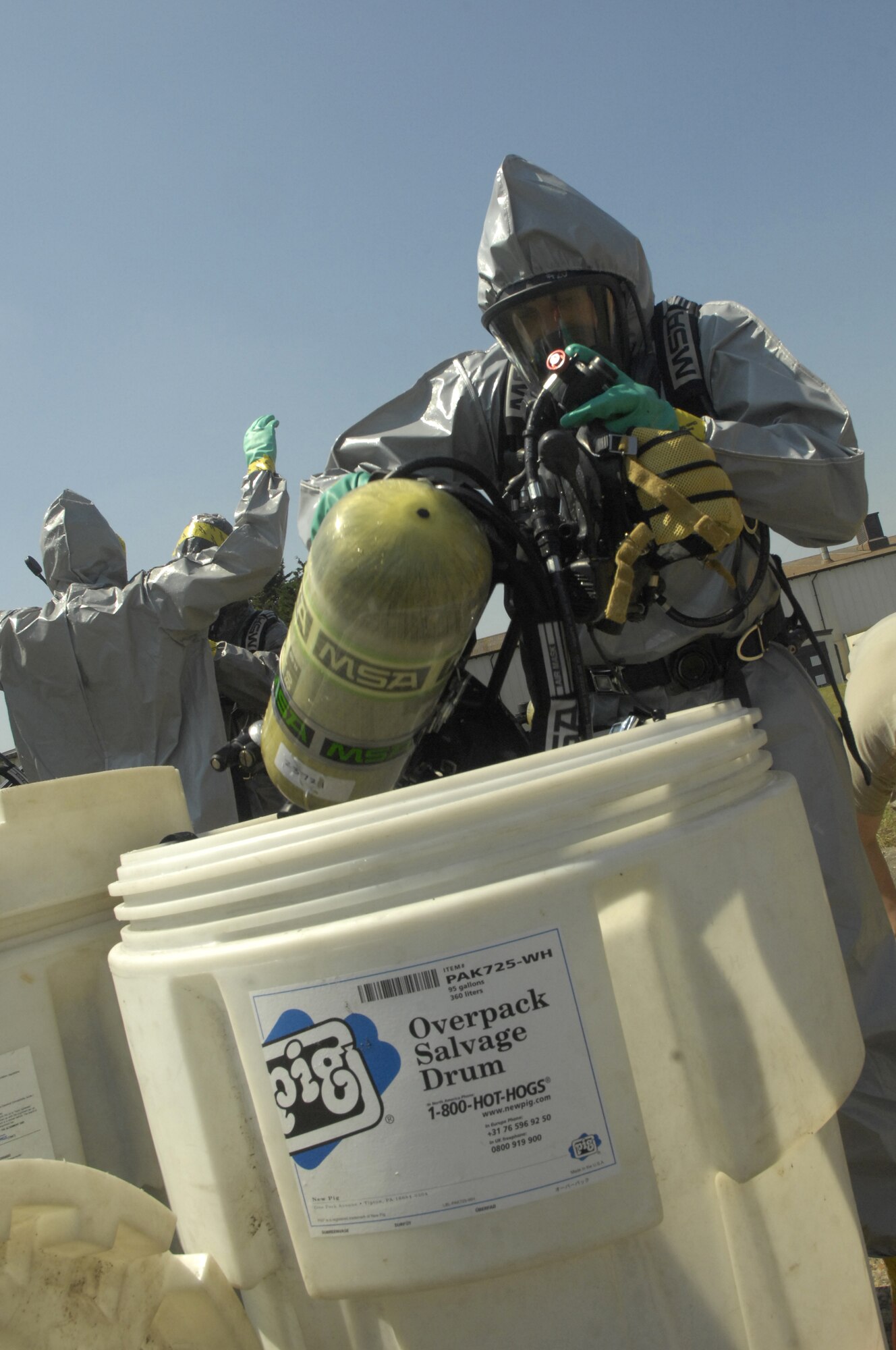 ROYAL AIR FORCE LAKENHEATH, England – Lee Alsop, 48th Civil Engineer Squadron firefighter, places his self-contained breathing apparatus into an "over-pack," a container designed to hold items potentially contaminated with hazardous materials, after processing through several decontamination stations here July 26, 2012. The 48th CES responded to a HAZMAT incident after several large batteries were found cracked and leaking acid. (U.S. Air Force photo by Tech. Sgt. Zachary Melin)