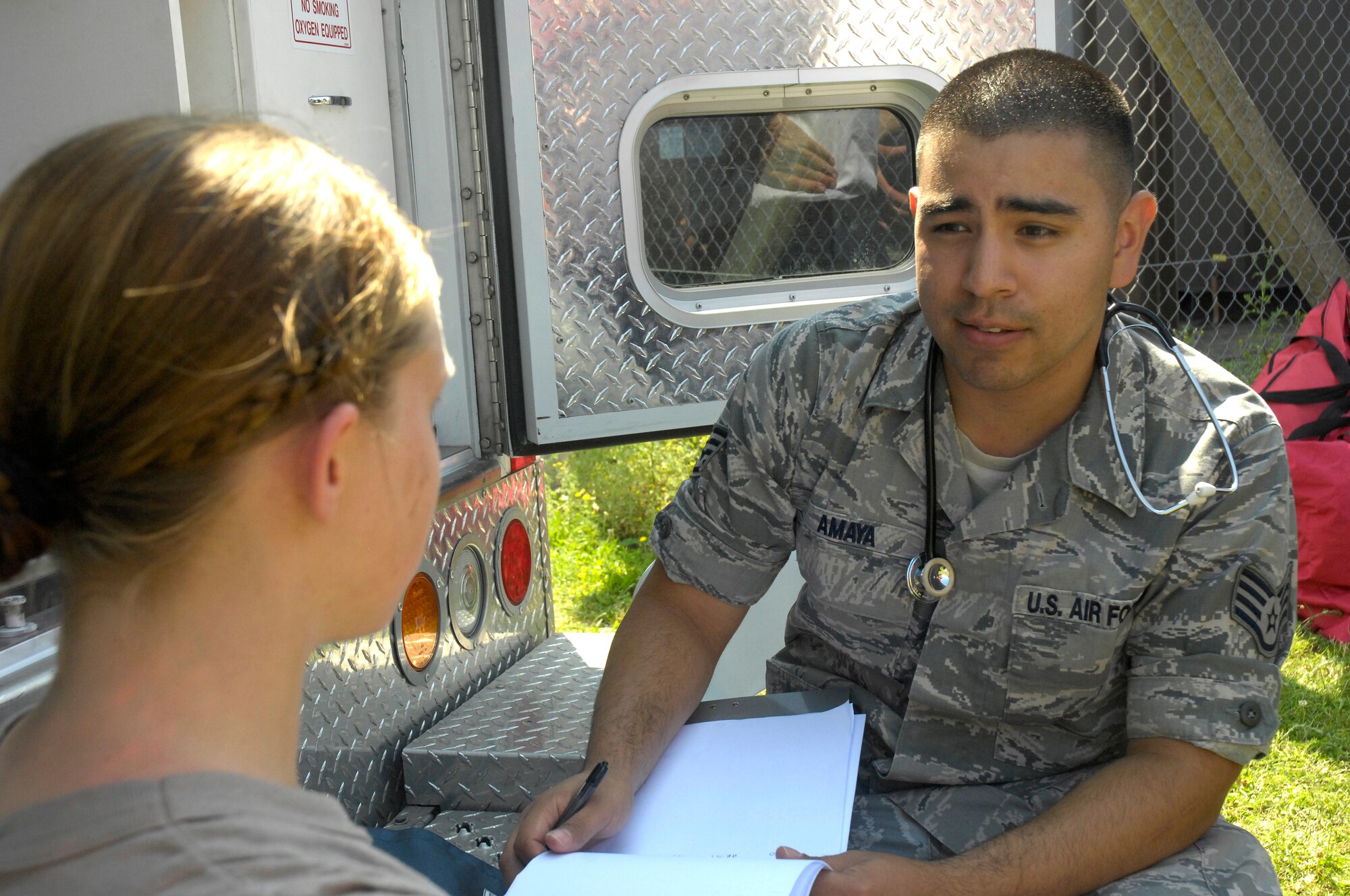 ROYAL AIR FORCE LAKENHEATH, England - Staff Sgt. Javier Amaya, 48th Medical Operations Squadron emergency medical technician, evaluates Airman 1st Class Ashley Eisenbarth, 48th Civil Engineer Squadron firefighter, for any sign of medical problems after she took part in a hazardous material containment operation here July 26, 2012. The 48th CES was called to respond to a HAZMAT incident after several large batteries were found cracked and leaking acid. (U.S. Air Force photo by Tech. Sgt. Zachary Melin)