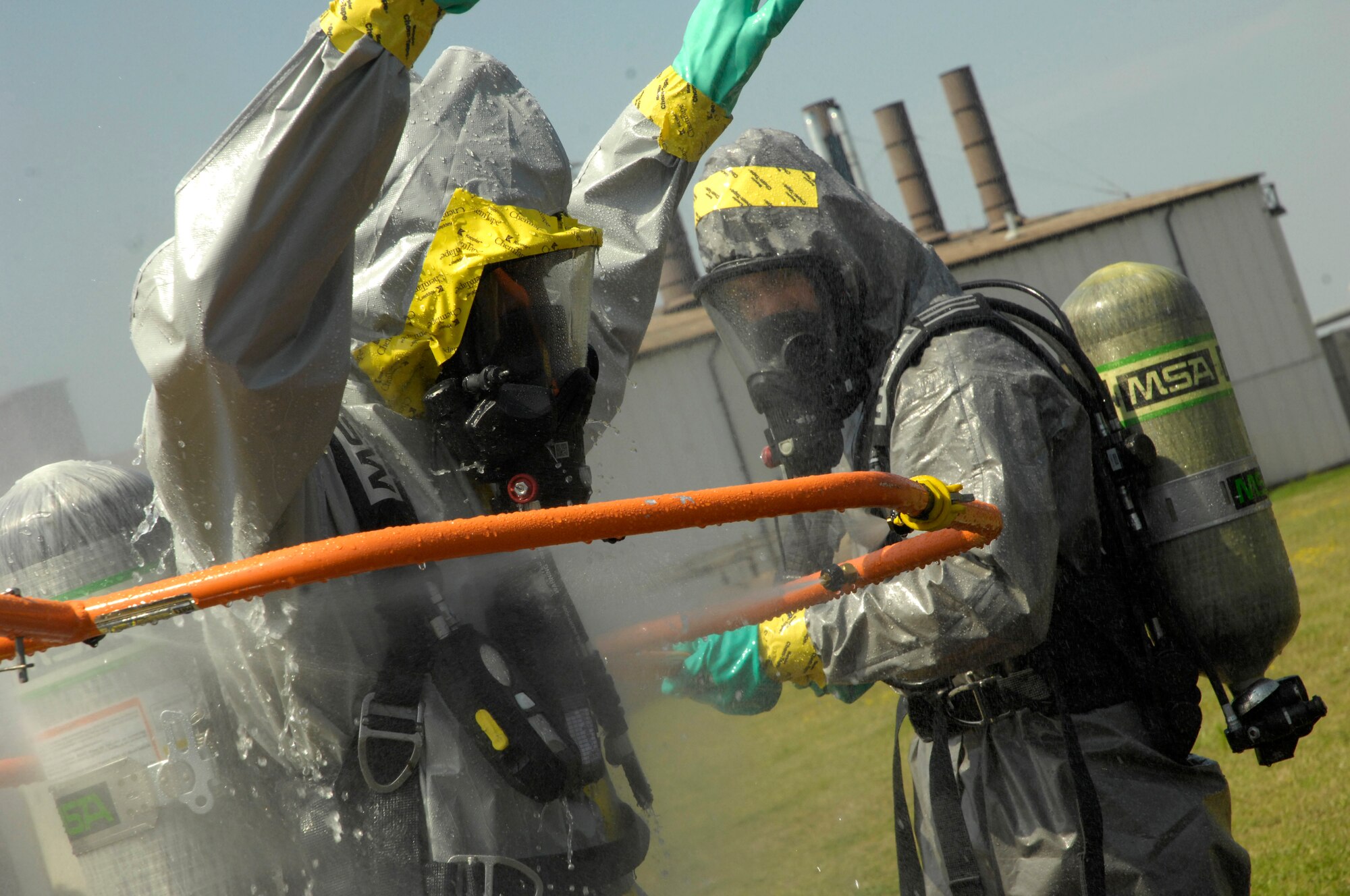 ROYAL AIR FORCE LAKENHEATH, England – A firefighter from the 48th Civil Engineer Squadron maneuvers one end of the decontamination system used to wash away any hazardous materials on a HAZMAT technician entry team member’s suit here July 26, 2012. The 48th CES responded to a HAZMAT incident after several large batteries were found cracked and leaking acid. (U.S. Air Force photo by Tech. Sgt. Zachary Melin)