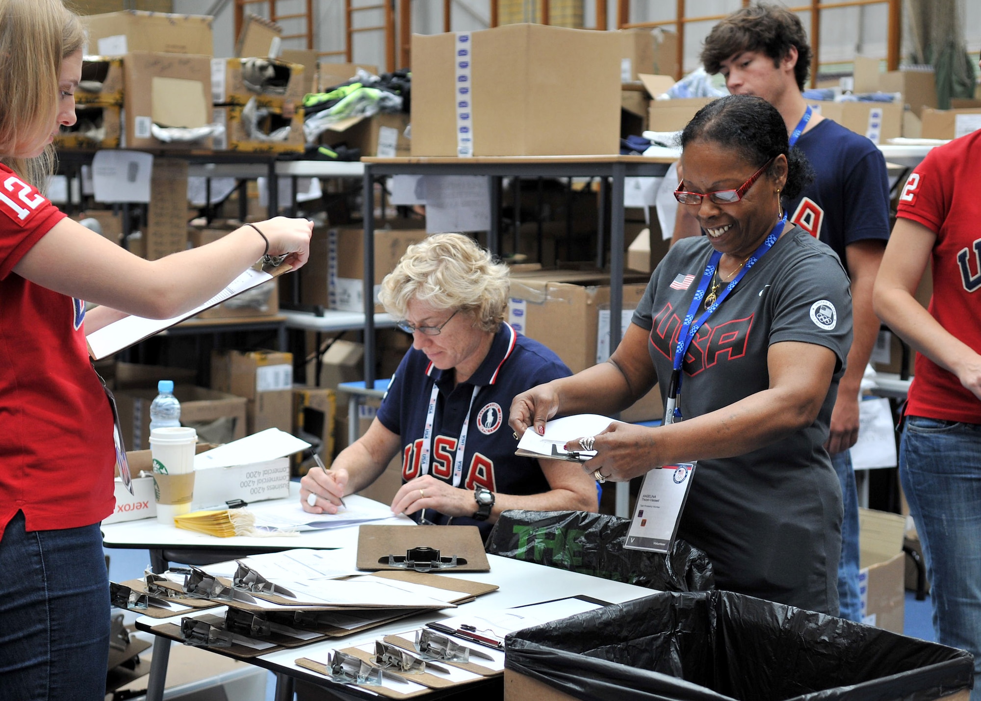 LONDON, England – Angelina Trezel-Vassell, gray shirt, wife of Maurice Vassell, 48th Force Support Squadron, RAF Lakenheath, organizes charts at the USA Olympic team processing center July 25, 2012. More than 300 volunteers from  U.S. Visiting Forces military bases across the United Kingdom signed up to help in preparation for the upcoming 2012 Olympic Games. (U.S. Air Force photo/Senior Airman Jerilyn Quintanilla)