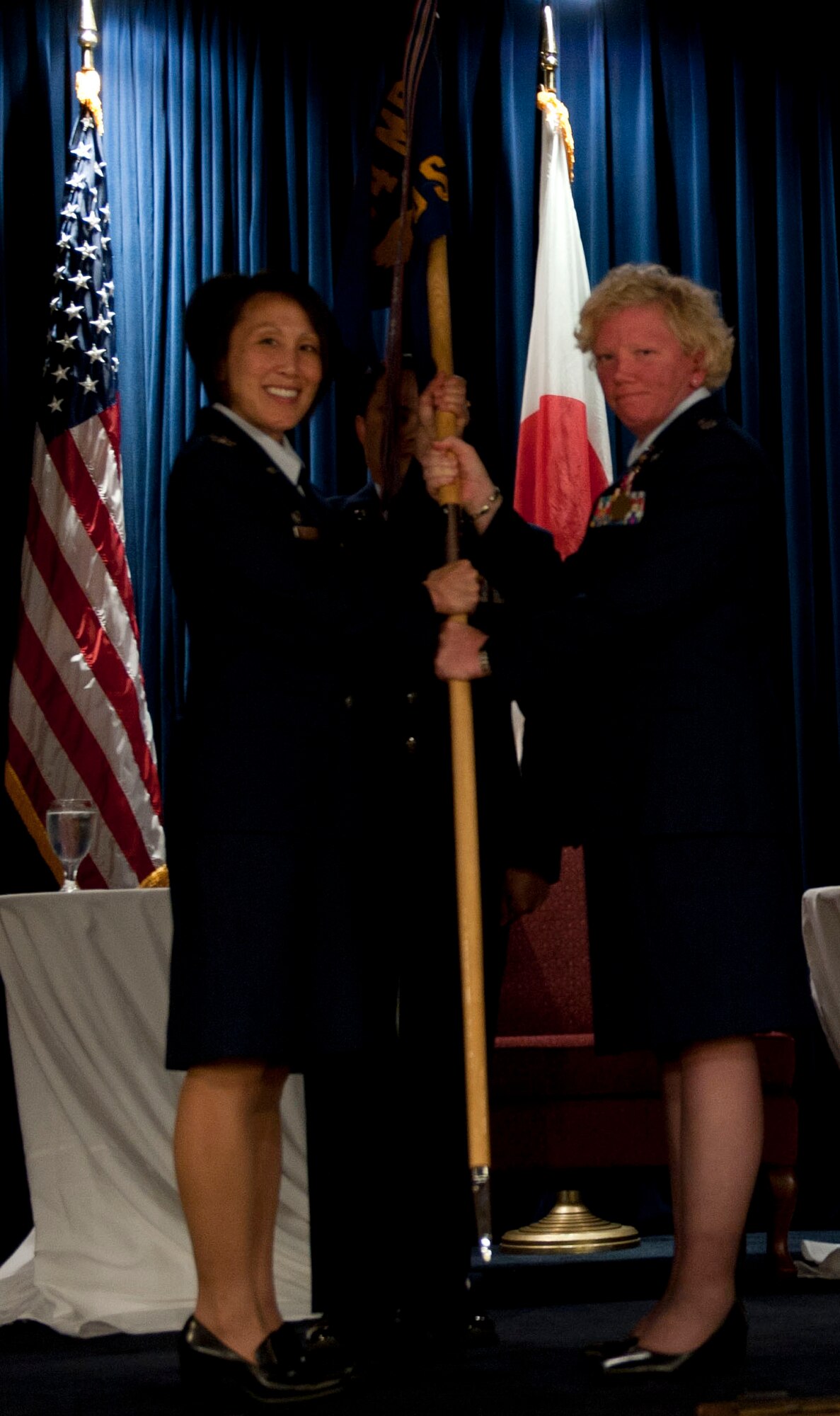 YOKOTA AIR BASE, Japan -- Lt. Col Mary O'Loughlin, 374th Medical Operations Squadron outgoing commander, passes the unit guidon to Col. Eveline Yao, commander of the 374th Medical Group, during the 374 MDOS change of command at Yokota Air Base, Japan, July 30, 2012. The passing of the guidon symbolizes the passing of responsibility, a tradition dating back to Roman times. (U.S. Air Force photo by Airman 1st Class Krystal M. Garrett)