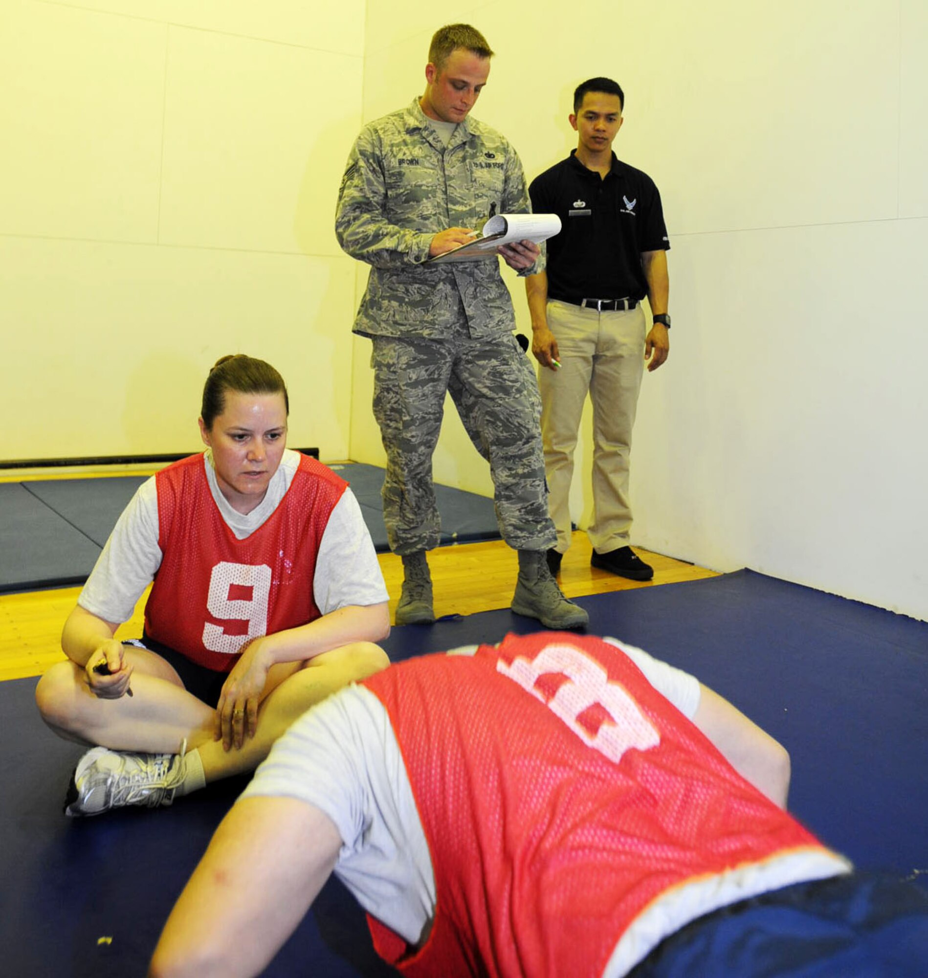U.S. Air Force Staff Sgt. Shane Brown, 35th Security Forces Squadron supply NCO, makes sure Airmen correctly administer their push-ups during a physical fitness test at Misawa Air Base, Japan, July 31, 2012. To earn a physical training leader certification, contact the health and wellness center Monday through Friday, 7:30.a.m. to 4:30 p.m. or call at 226-6550. (U.S. Air Force photo by Airman 1st Class Kenna Jackson/Released)