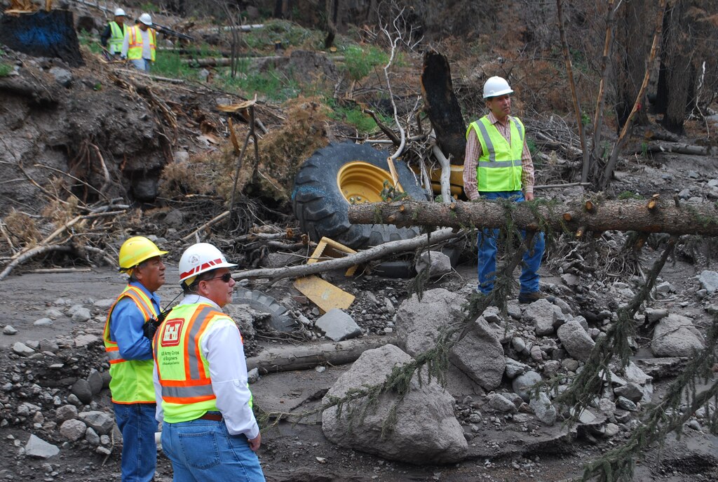 United States Senator Tom Udall (top) and members of the District took a tour of Santa Clara Pueblo’s burned canyon July 7. Udall stands next to a Corps’ bulldozer that was destroyed during flooding following last year’s Las Conchas Fire. Also pictured (bottom right) is Kris Schafer, chief of Project Management, and Walter Dasheno, governor of Santa Clara Pueblo.