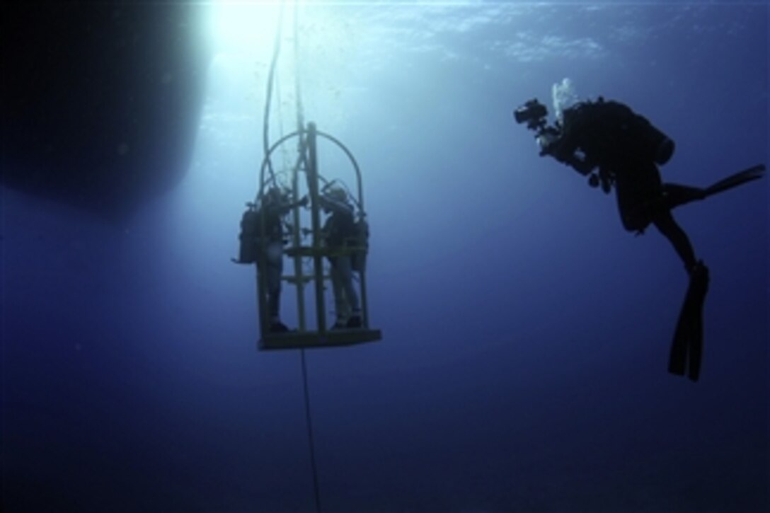 U.S. Navy Petty Officer 3rd Class Jumar Balacy, right, documents a surface supplied dive conducted in Mamala Bay, Hawaii, as part of Exercise Rim of the Pacific 2012 on July 27, 2012.  Twenty-two nations with more than 40 ships and submarines, more than 200 aircraft and 25,000 personnel are participating in the world's largest international maritime exercise in and around the Hawaiian Islands.  