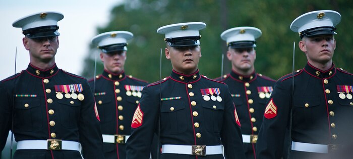 The parade staff marches into position after the pass in review during a Tuesday Sunset Parade at the Marine Corps War Memorial in Arlington, Va., July 24. Sgt. Maj. Micheal P. Barrett, sergeant major of the Marine Corps, served as the hosting official for this parade, which featured noncommissioned officers in positions, such as the parade staff, traditionally held by officers and staff noncommissioned officers.