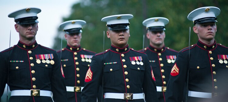 The parade staff marches into position after the pass in review during a Tuesday Sunset Parade at the Marine Corps War Memorial in Arlington, Va., July 24. Sgt. Maj. Micheal P. Barrett, sergeant major of the Marine Corps, served as the hosting official for this parade, which featured noncommissioned officers in positions, such as the parade staff, traditionally held by officers and staff noncommissioned officers.