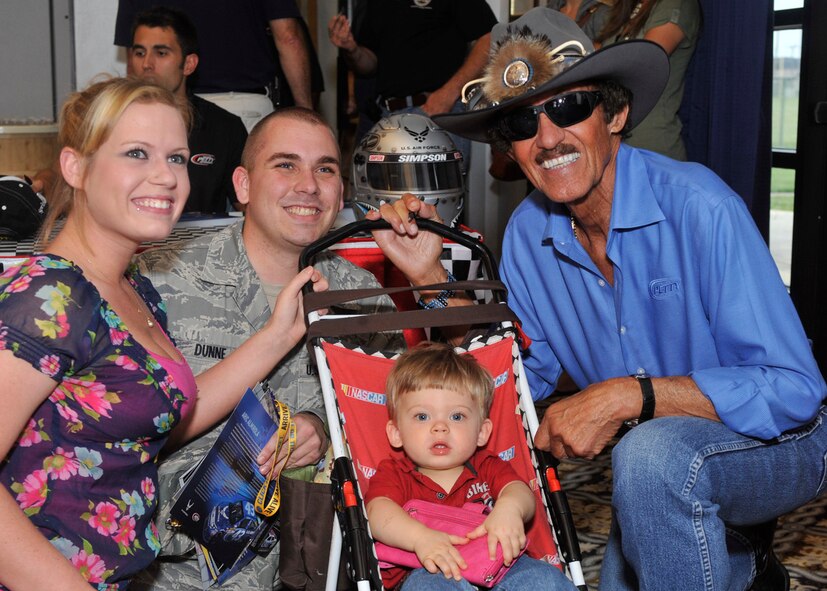 Airman 1st Class Matthew Dunne, his wife, Kimberly, and their son, Bo, pose with Richard Petty, owner of Richard Petty Motorsports, at the NASCAR Social June 1, 2012, at Dover Air Force Base, Del. The NASCAR Social offered families the opportunity to meet NASCAR members who will participate in the Fed Ex 400 benefitting Autism Speaks and the 5 Hour Energy 200 at Dover International Speedway. (U.S. Air Force photo by Airman 1st Class Samuel Taylor)