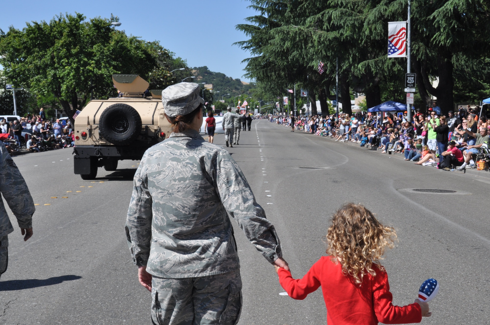 Capt. Melissa Milner, 60th Air Mobility Wing public affairs, and Alyvia Groeling, 5, daughter of Tech. Sgt. Richard Groeling, 60th Force Support Squadron, show their community support May 26 by representing Travis Air Force Base in the Vacaville Fiesta Days parade. (U.S. Air Force photo/Airman 1st Class Madelyn Ottem)