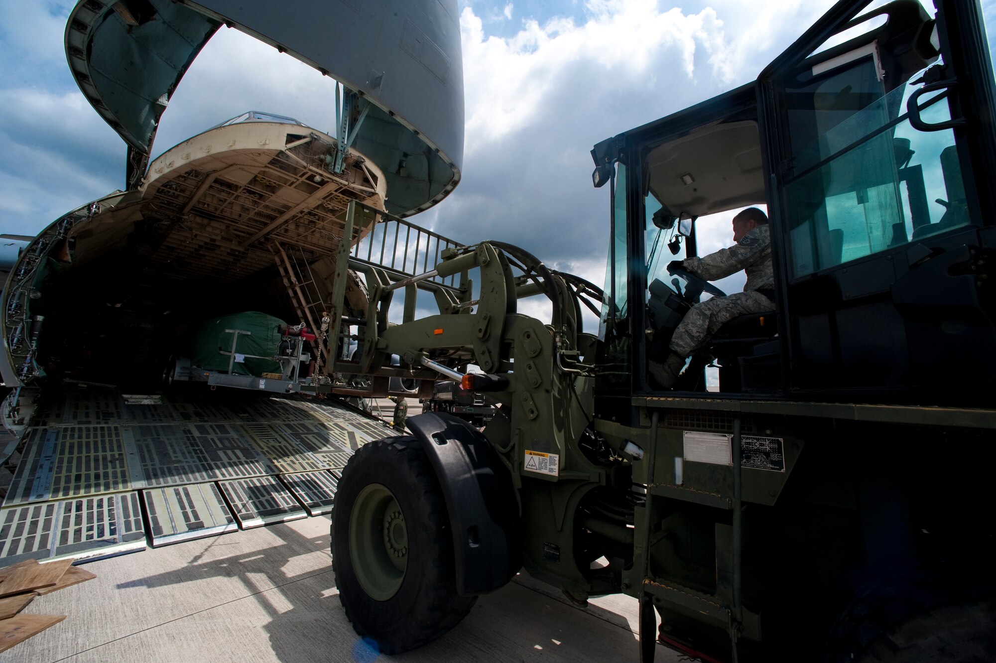 U.S. Air Force Senior Master Sgt. Paul Benson, A C-5 Loadmaster Advisor with the 337th Airlift Squadron out of Dover Air Force Base, Del., places wood to lift a trailer off the ground on the flightline at Hurlburt Field, Fla., June 1st 2012. The trailer was carrying a training submarine to be used at a Navy school house. (U.S. Air Force photo/Airman 1st Class Christopher Williams)(Released)