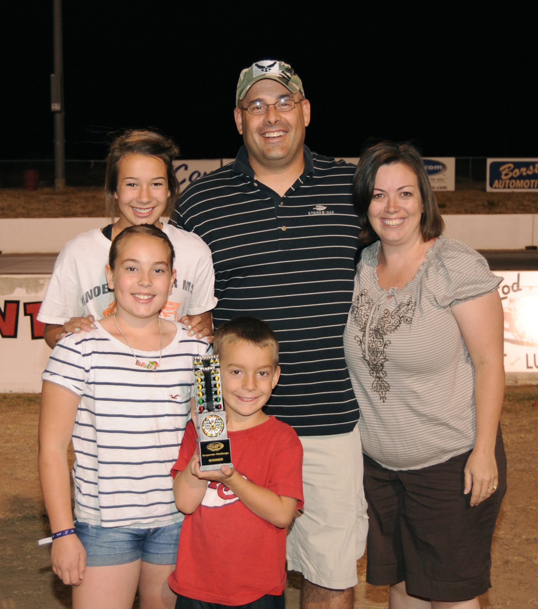 U.S. Air Force Lt. Col. Trace Steyaert, 355th Logistics Readiness Squadron commander, poses with his family after defeating 49 other racers to win the Southwestern International Raceway drag race tournament May 30. Identical cars were used, so the skill of the driver was the only factor in winning the race. (U.S. Air Force photo by Airman 1st Class Michael Washburn/Released)