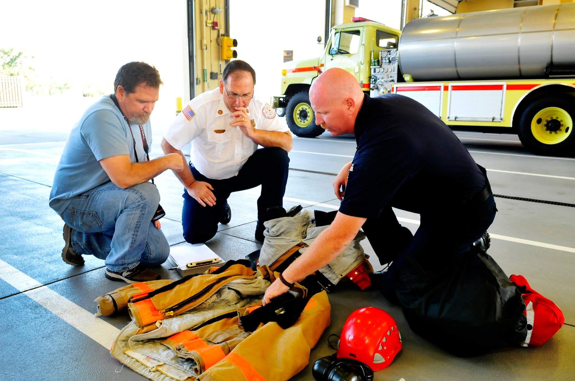 Bob O'Donnell, still photographer,talks with Thomas Schoonover and Steven Smith about a photo displaying proper PPE. A crew was at Robins May 21-23 to shoot photos and film segments for an Air Force Health and Safety Officer training course. (U. S. Air Force photo by Sue Sapp)