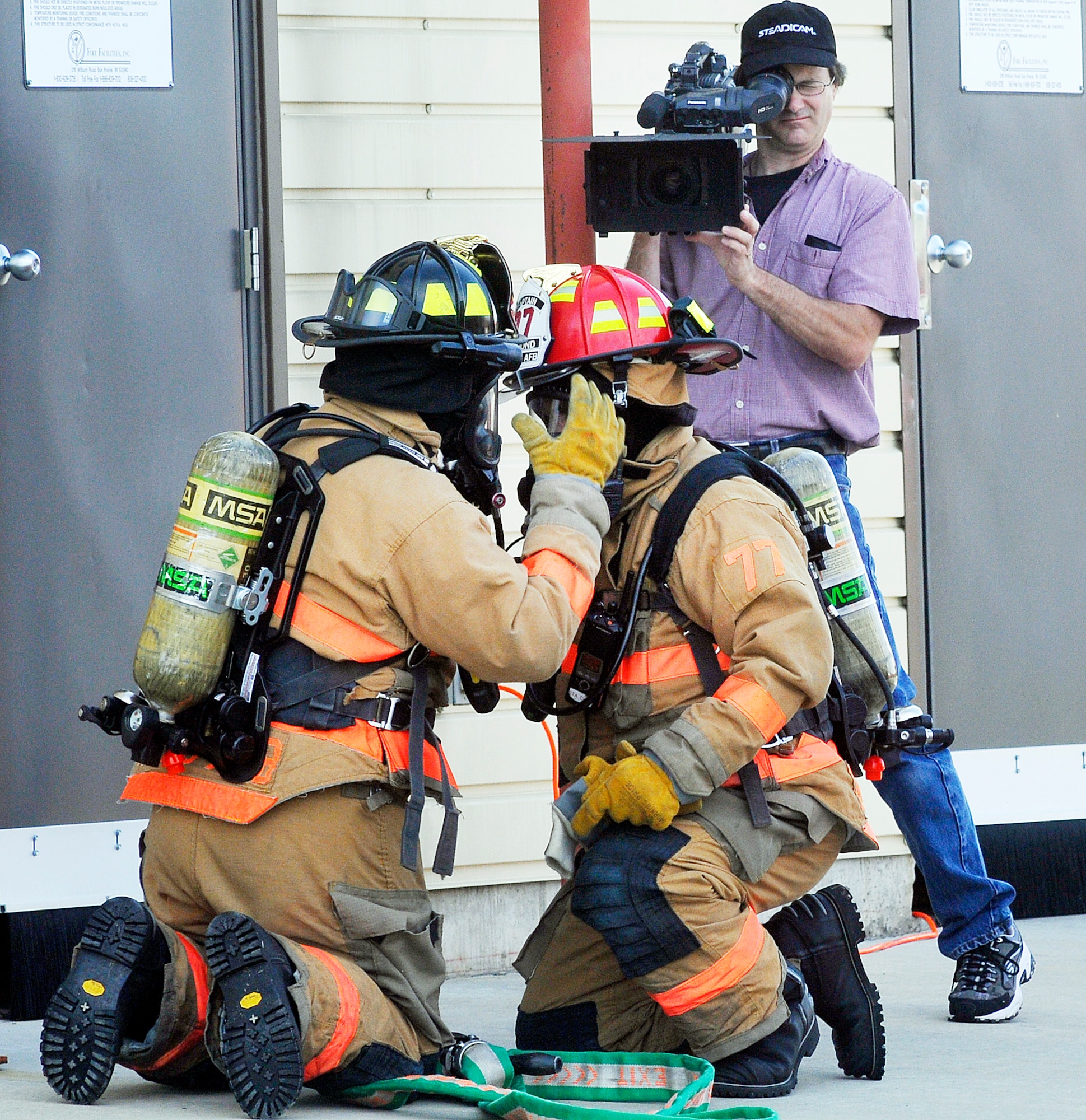 Tim Phillips, at right, a director and camera operator from Power Train Inc., films Robins firefighters at the base training facility. A crew was at Robins May 21 through 23 to shoot photos and film segments for an Air Force Health and Safety Officer course. Forest Johnson, 78th Civil Engineer Group Fire Emergency
Services Division fire chief, said the video allows his team the opportunity to showcase its expertise and experience.“I’m honored and proud to be able to showcase our personnel and facilities,” he said.
 The training video will be distributed to all Air Force fire emergency departments. (U. S. Air Force photo by Sue Sapp)