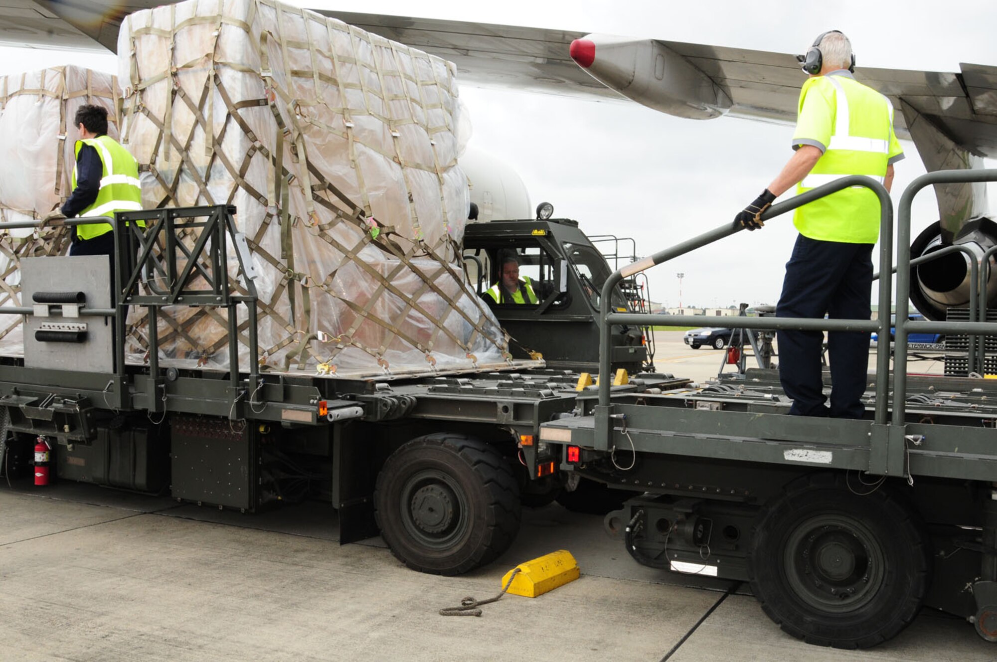 RAF MILDENHALL, England – Air-freight handlers from the 727th Air Mobility Squadron bring cargo on a “K-loader” to transfer onto a commercial aircraft here May 31, 2012. Cargo is brought in on a weekly basis, and consists of high priority items such as aircraft parts and mail, as well as some household goods. The 727th AMS handles 5,000 tons of cargo annually, and saw 12,000 passengers in 2011. Cargo comes in from all around the world, and all of it – whether arriving by sea or air – first has to go through the Army Surface Deployment Distribution Center – before being processed through RAF Mildenhall.  (U.S. Air Force photo/Karen Abeyasekere)