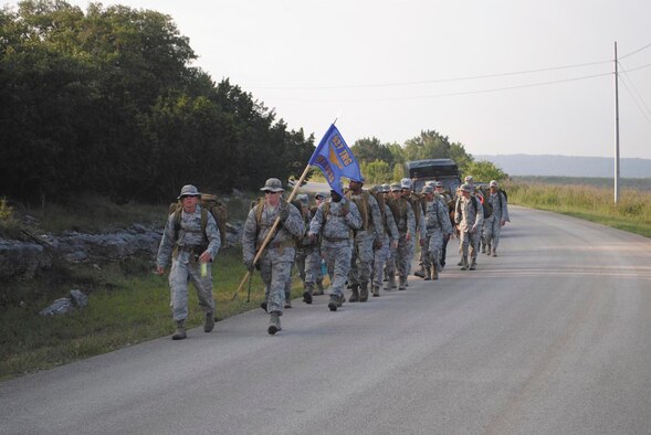 Airmen from the 937th Training Support Squadron execute a ruck march May 18 at the Medical Readiness Training Center, Joint Base San Antonio-Camp Bullis. The march was held as part of a final commander’s call for Lt. Col. Jon T. Mohatt, who leaves for an assignment in Falls Church, Va., in June. (U.S. Air Force photo/Staff Sgt. Andrew Pearson)