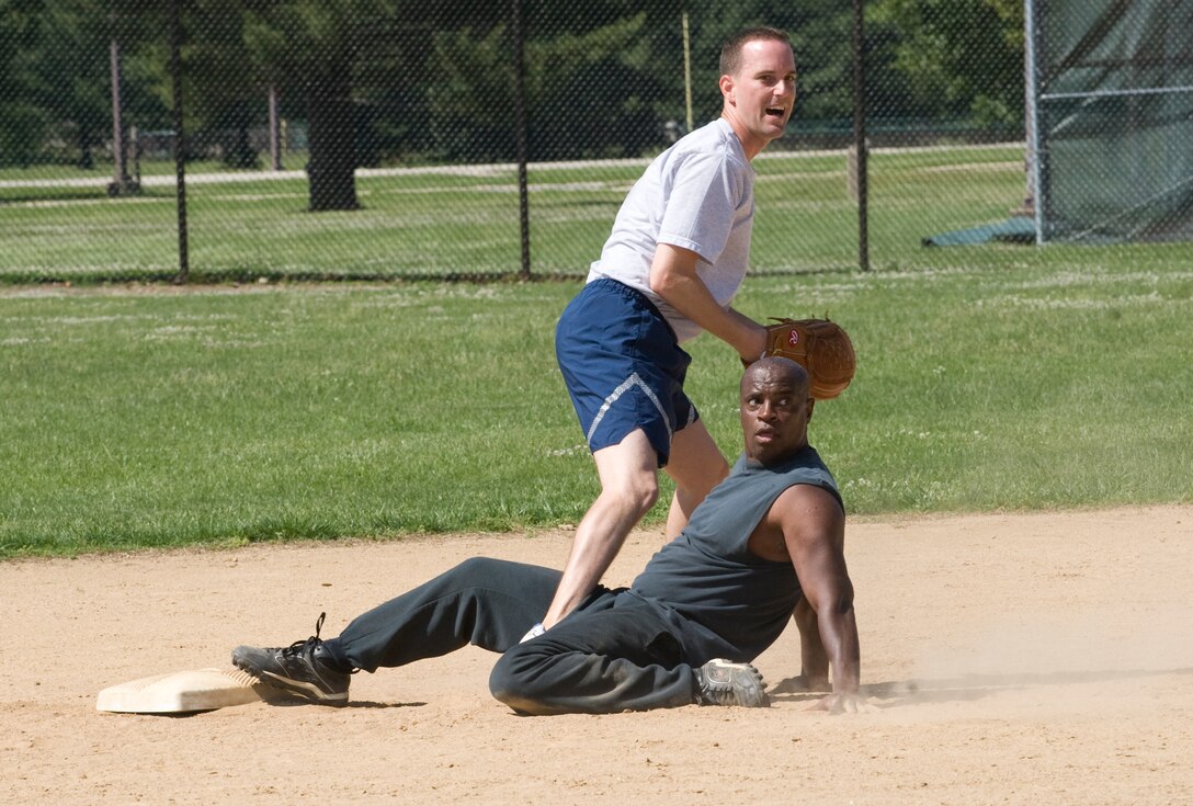 Ben Keith, an 11th Civil Engineer Squadron team member, slides safely into second base against Greg Coleman, an 11th Security Forces Squadron team member, during a championship 11th Wing Sports Day softball game May 24.  (Photo/Bobby Jones) 