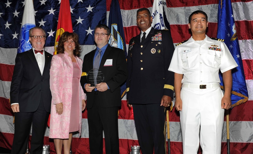 Peter Wertimer, Charleston Chamber of Military Policy council chairman, Julie Gerthoffer, Charleston Chamber of Military Relations Committee and U.S. Army Lt. Gen. Vincent Brooks, Third Army commanding general, present Christopher Rynearson, the Space and Naval Warfare Systems Command Information Technology specialist, the 'Civilian Employee of the Year' award, alongside his commanding officer, CDR Baldomero Garcia, SPAWAR deputy chief, during 'Salute to the Military' May 23, 2012 at the North Charleston Convention Center, S.C. This is the eighth year the Charleston Metro Chamber of Commerce recognized the local active-duty, reserve, and civilian personnel for their community service above and beyond their call of duty. (U.S. Air Force photo/Airman 1st Class Ashlee Galloway)
