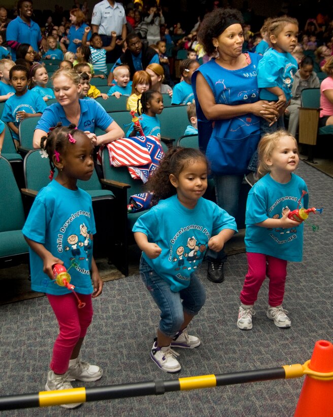 A trio of Child Development Center children dance along to the sights and sounds of the Sesame Street characters during the show at the Reel Time Base Theater on May 22.  The children were treated to a 30-minute show by the full Sesame Street cast and were also able to interact with the Sesame Street characters for hugs and photo opportunities during the show. (Photo/Bobby Jones) 
