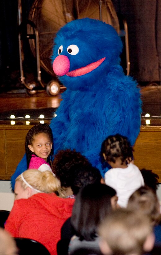 Grover, a Sesame Street character, gives a hug to a young Team Andrews member during the audience interaction portion of a show at the Reel Time Base Theater on May 21. (Photo/Bobby Jones) 