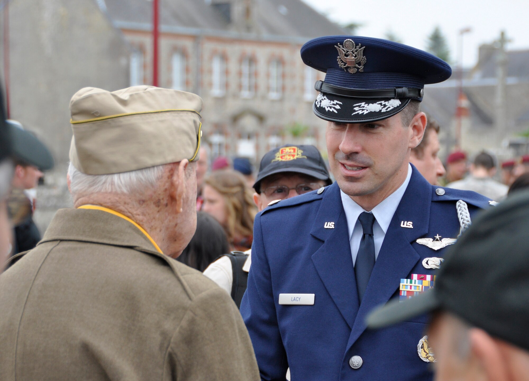 Air Force Lt. Col. John Lacy speaks with a World War II veteran June 1, 2012, in Picauville, France. U.S. and allied forces attended a commemorative ceremony in the Picauville town square honoring the Airmen and soldiers who lost their lives during the famous Normandy D-Day invasion. Both the Airmen and soldiers were killed when their C-47 aircraft was brought down by German anti-aircraft artillery at 1:20 a.m., June 6, 1944 during the invasion of France. Lacy is the assistant U.S. air attaché to France with the Defense Attaché Office in Paris. (U.S. Air Force photo/Staff Sgt. Stephen J. Collier)