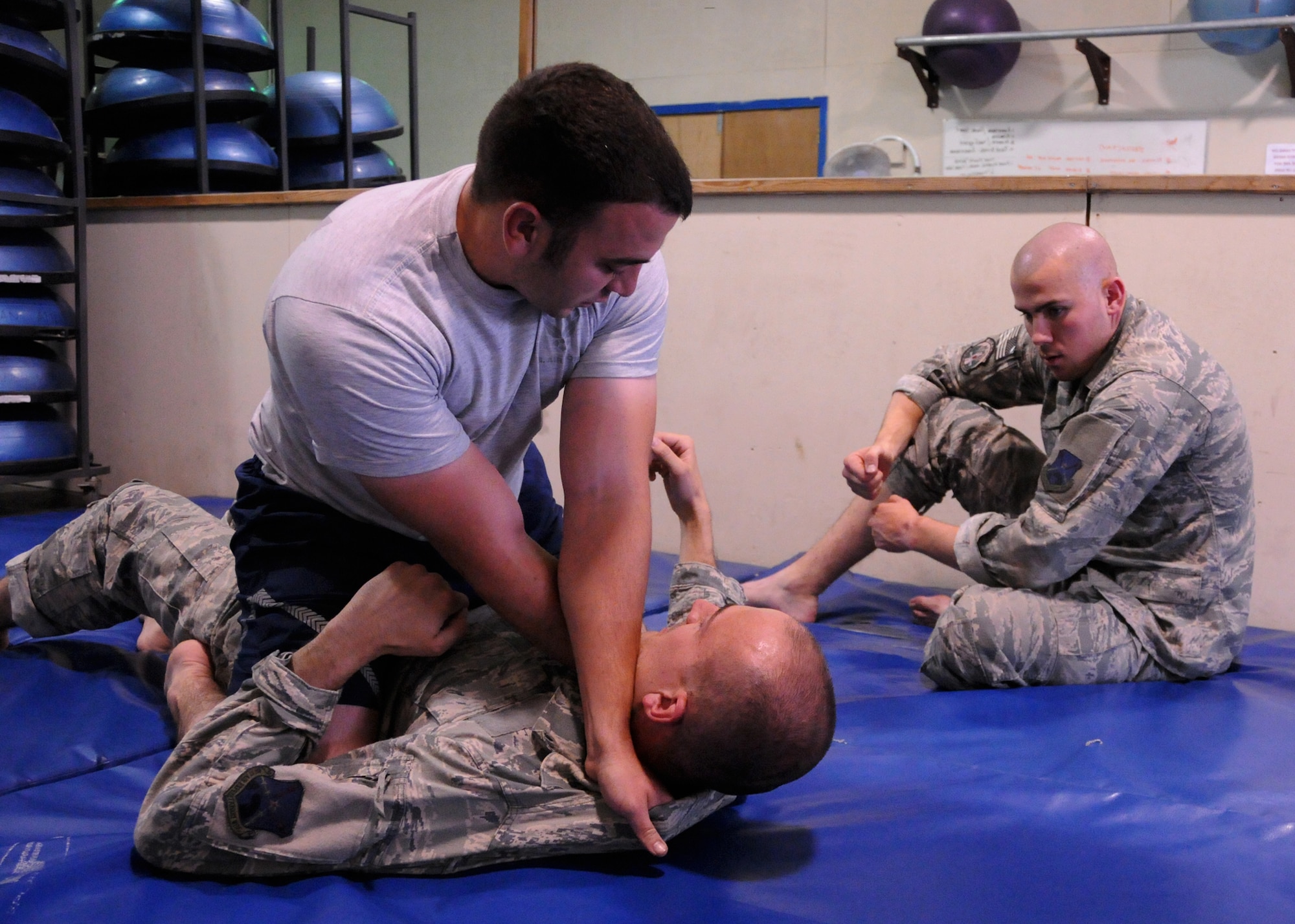Staff Sgt. Timothy Ethridge, a 73rd Expeditionary Air Control Squadron aerospace ground equipment supervisor, shows his two Jiu Jitsu students the cross-collar choke method in the full-mount position, here at the Freedom Gym at Kandahar Airfield, Afghanistan, May 29, 2012. The class concentrates on some stand-up moves but mostly centers on taking the opponent to the ground. (U.S. Air Force photo/Staff Sgt. Heather Skinkle)
