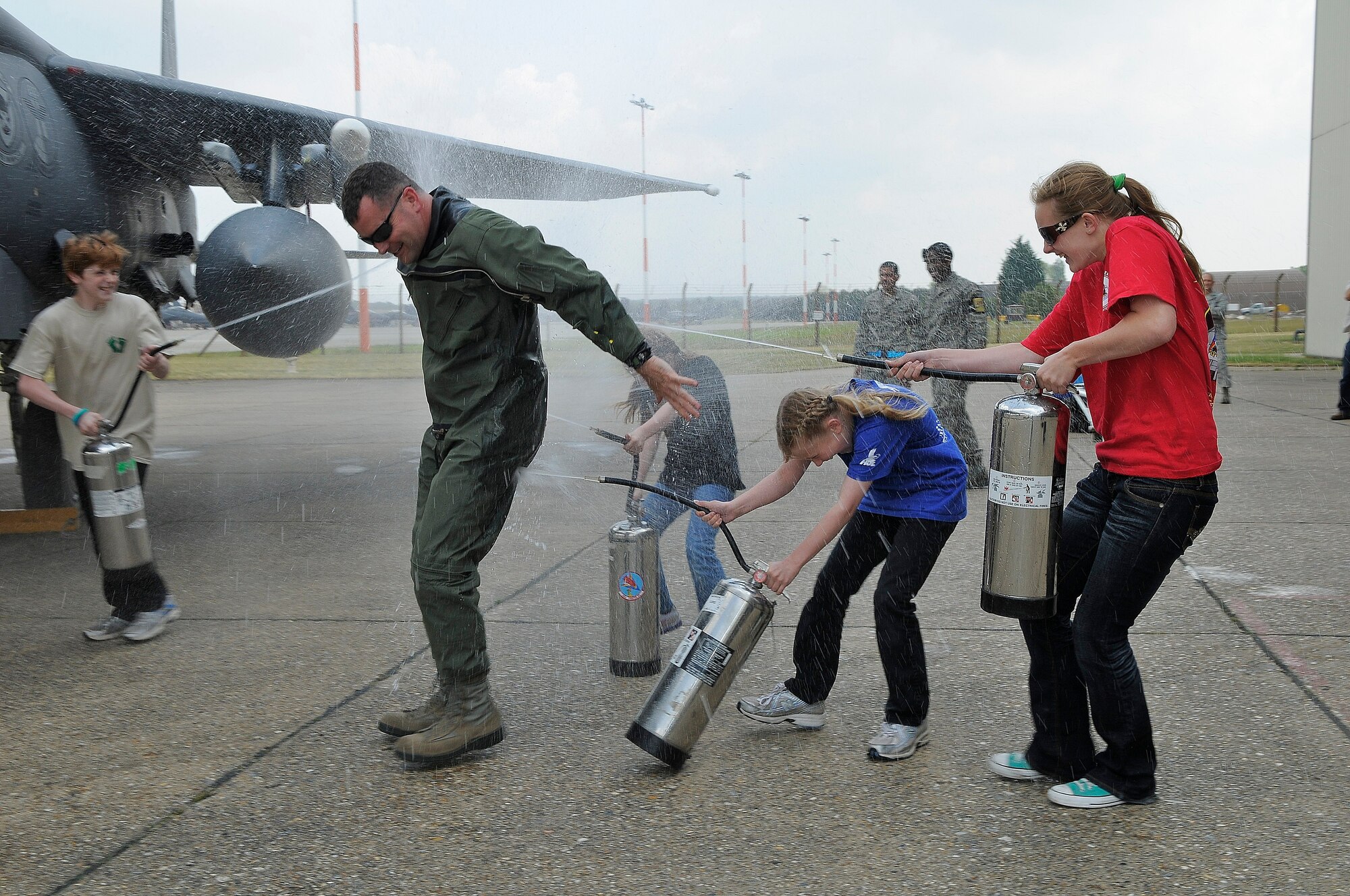 ROYAL AIR FORCE LAKENHEATH, England -- Col. Daniel Orcutt, 48th Operations Group commander, is sprayed with water by his children after his "fini" flight May 30, 2012. Orcutt piloted his final flight in an F-15E Strike Eagle after serving two years as the 48th OG commander. (U.S. Air Force photo by Staff Sgt. Connor Estes)