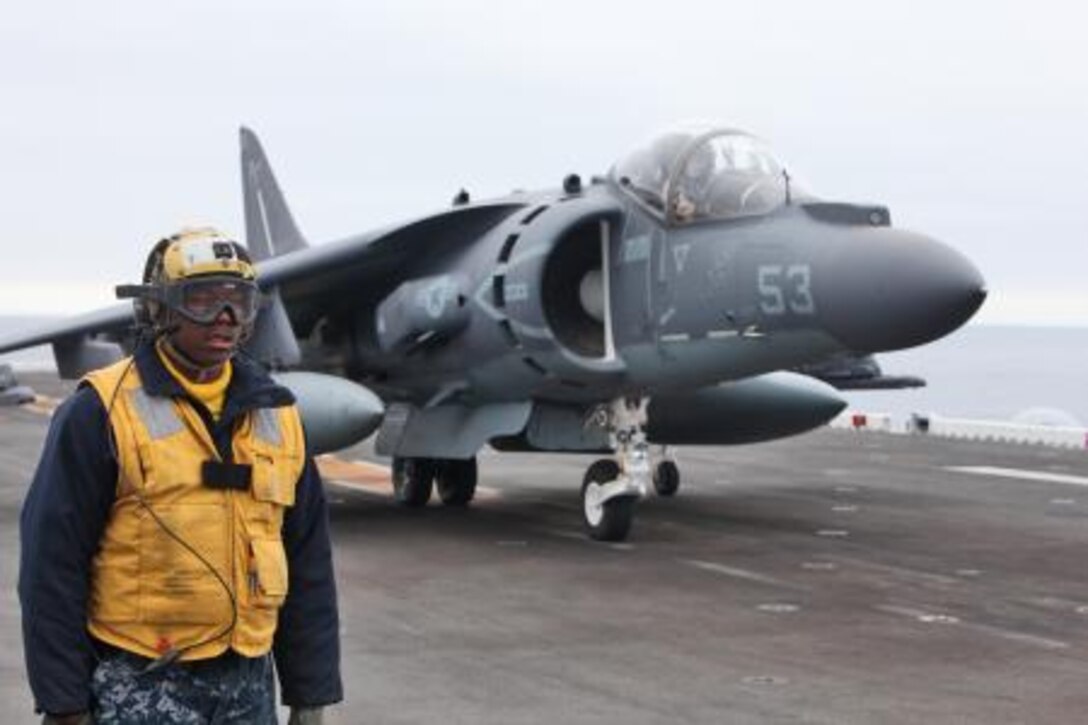 Petty Officer 2nd Class Landon Jameson, aviation boatswain’s mate, USS Peleliu, guides an AV-8B Harrier after landing on the flight deck of the USS Peleliu during daily flight operations as part of PHIBRON Three and 15th MEU’s PHIBRON-MEU Interoperability Training off the coast of southern California, June 1. The purpose of the exercise is to give Marines and sailors the opportunity to become familiar working together as a blue-green team, a must when it comes to flight deck operations.::r::::n::::r::::n::::r::::n::