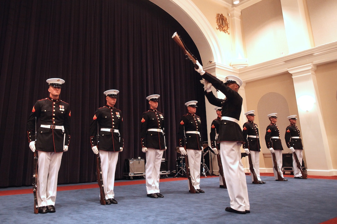 Lance Cpl. Carlton Williams, Marine Corps Silent Drill Platoon rifle inspector, inspects the wood on a M1 Garand rifle during a modified Friday Evening ceremony in Crawford Hall at Marine Barracks Washington June 1. The full scale parade was cancelled due to inclement weather but a special performance took place indoors for a small group of guests.