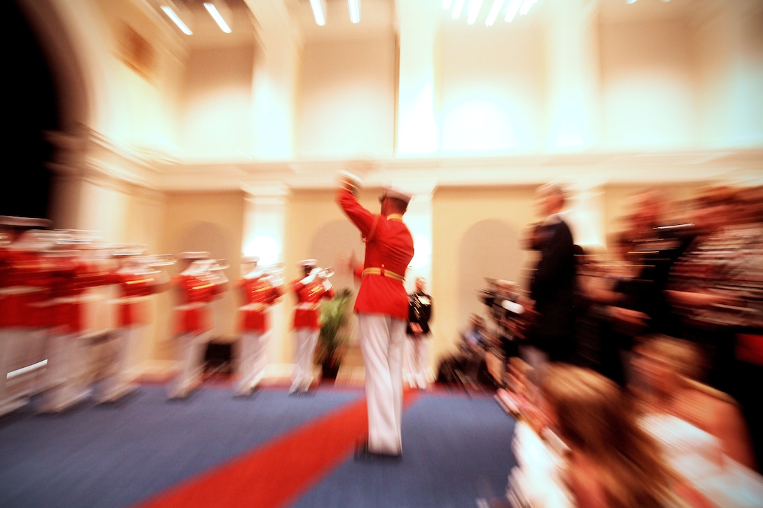 Capt. Christopher Hall, U.S. Marine Drum & Bugle Corps executive officer, conducts the unit during a modified Friday Evening ceremony in Crawford Hall at Marine Barracks Washington June 1. The full scale parade was cancelled due to inclement weather but a special performance took place indoors for a small group of guests.
