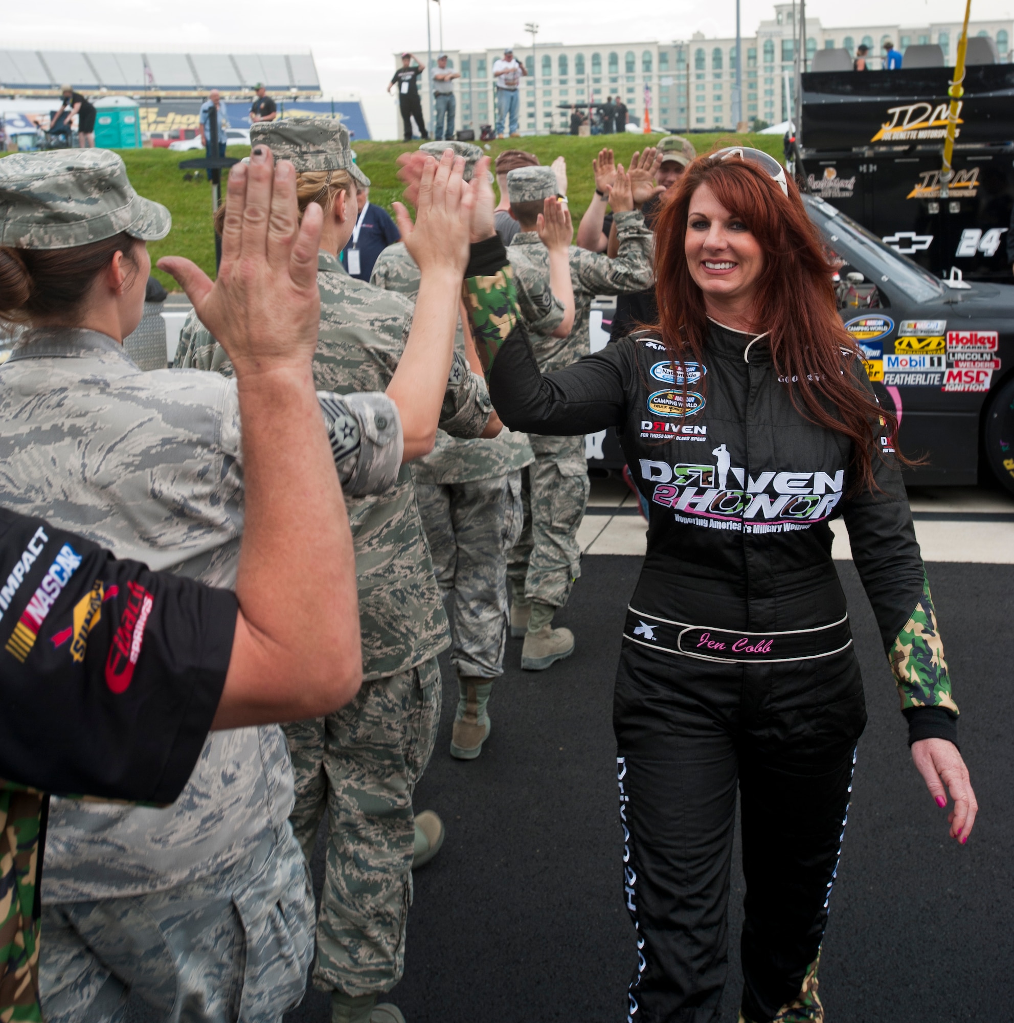 Jennifer Jo Cobb, owner and driver of the Driven 2 Honor No. 10 Camping World Series truck, gives high fives to her team, including service members from the 436th Airlift Wing, before the Lucas Oil 200 June 1, 2012, at Dover International Speedway, Del. Cobb created Driven 2 Honor in order to honor America’s military women. (U.S. Air Force photo by Senior Airman Jacob Morgan)