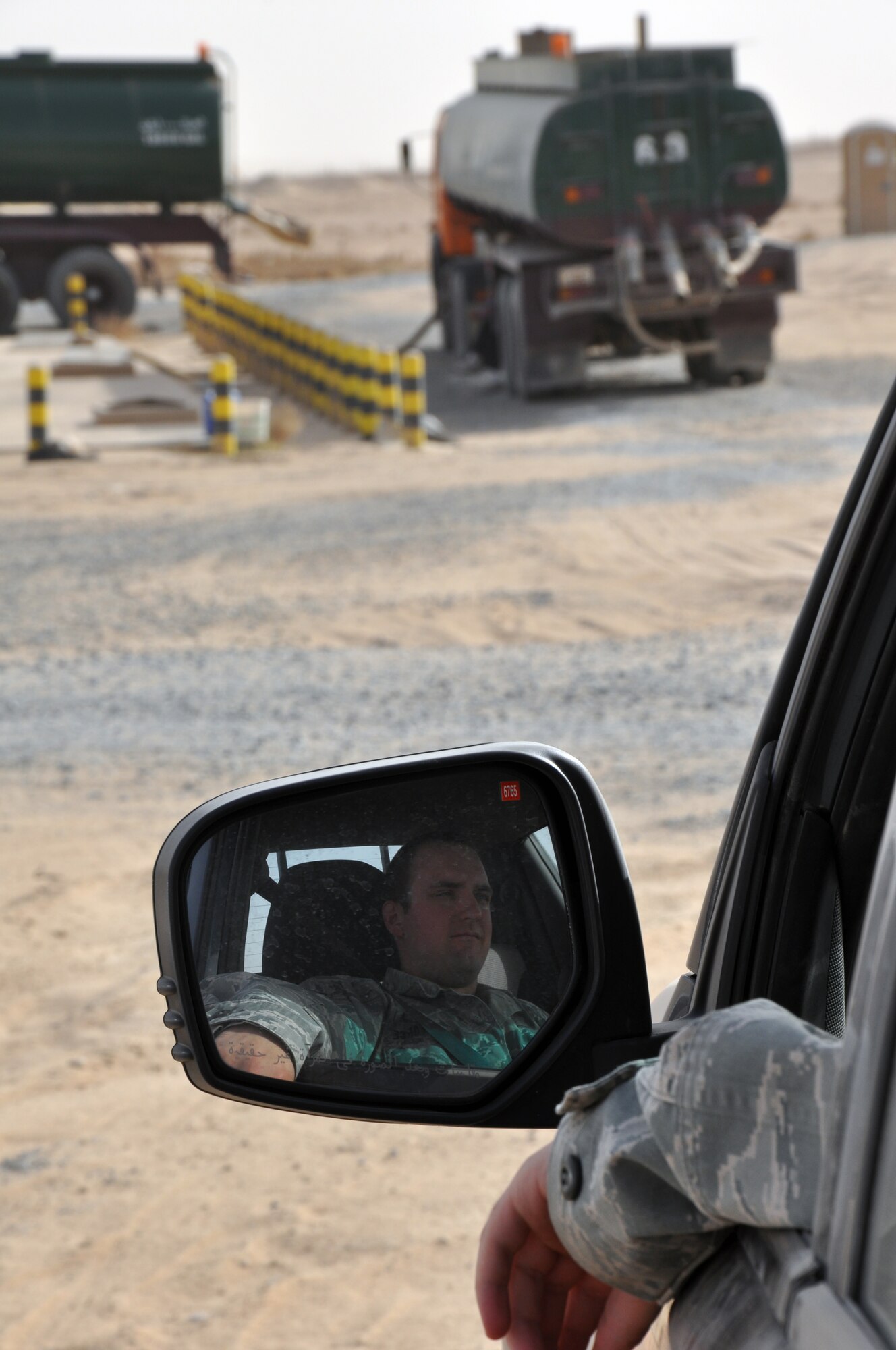 U.S. Air Force Senior Airman Michael Housler, 386th Expeditionary Civil Engineer Squadron Force Protection Flight Septic Waste Removal Escort Team, watches contractors empty one of the septic tanks at an undisclosed location, Southwest Asia, May 22, 2012.  SWRE Airmen escort septic trucks from the septic pits to the Green Mile every day, while keeping an eye on what the contractors are doing to ensure there is no intel gathered that could be used against the base and its personnel.  Housler is an Emporium, Pa., native deployed from the 354th Communications Squadron, Eielson Air Force Base, Alaska. (U.S. Air Force photo/Tech. Sgt. Stacy Fowler)