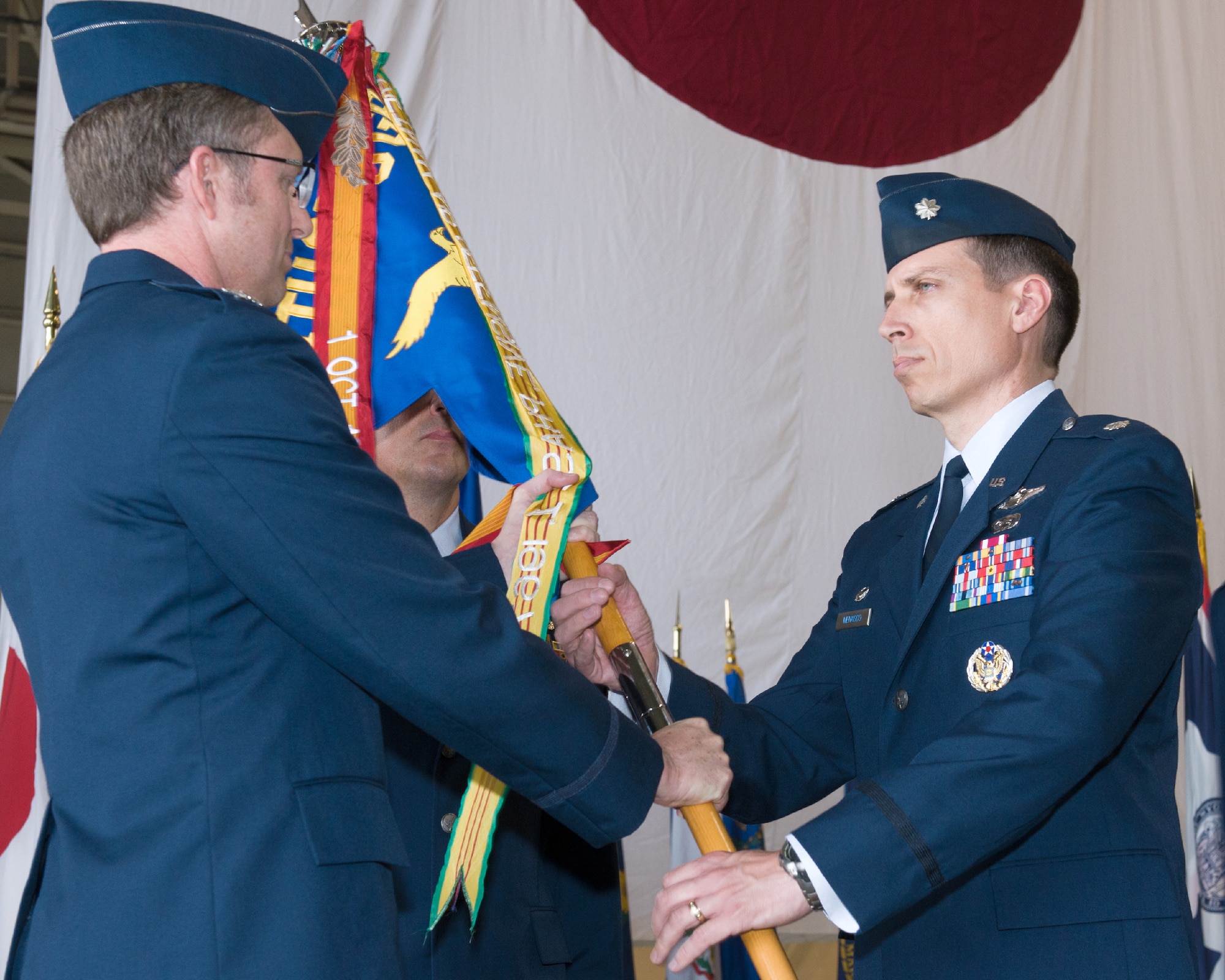YOKOTA AIR BASE, Japan -- Col. David Gould II, 374th Operations Group commander, left, passes the guidon to Lt. Col. Jeffrey Menasco, incoming 36th Airlift Squadron commander, right, during the 36th AS change of command ceremony at Yokota Air Base, Japan, on June 1, 2012. Menasco was the Director of Staff for the 374th Airlift Wing, Yokota AB. (U.S. Air Force photo by Osakabe Yasuo)