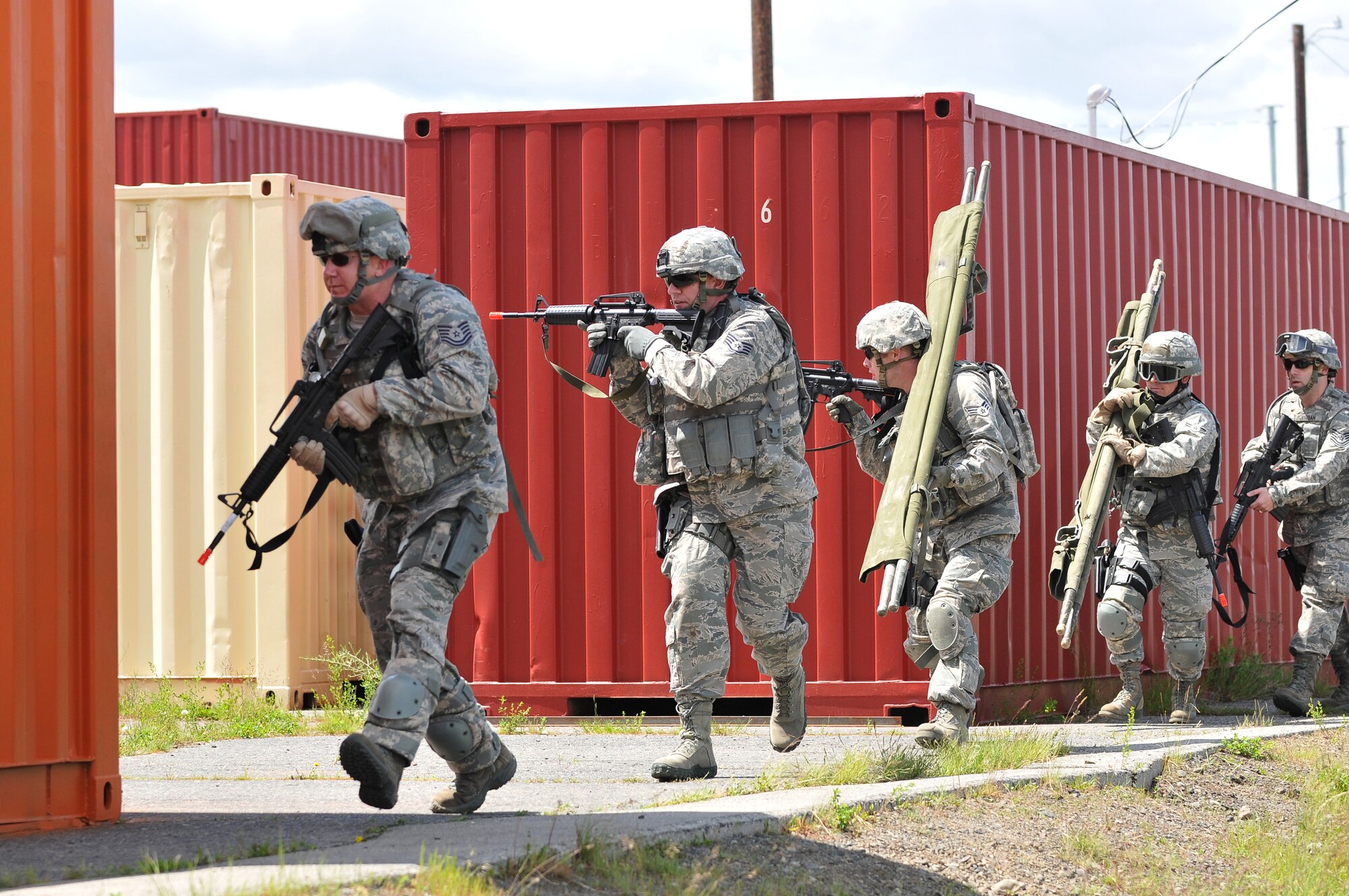 Members of the 141st Security Forces Squadron return fire while advancing to injured personnel during a simulated aircraft incident at Fairchild Air Force Base, Wash., June 2, 2012. 141st SFS members participated in several different training scenarios during the simulated peace-keeping mission. (U.S. Air Force photo by Staff Sgt. Anthony Ennamorato/Released)