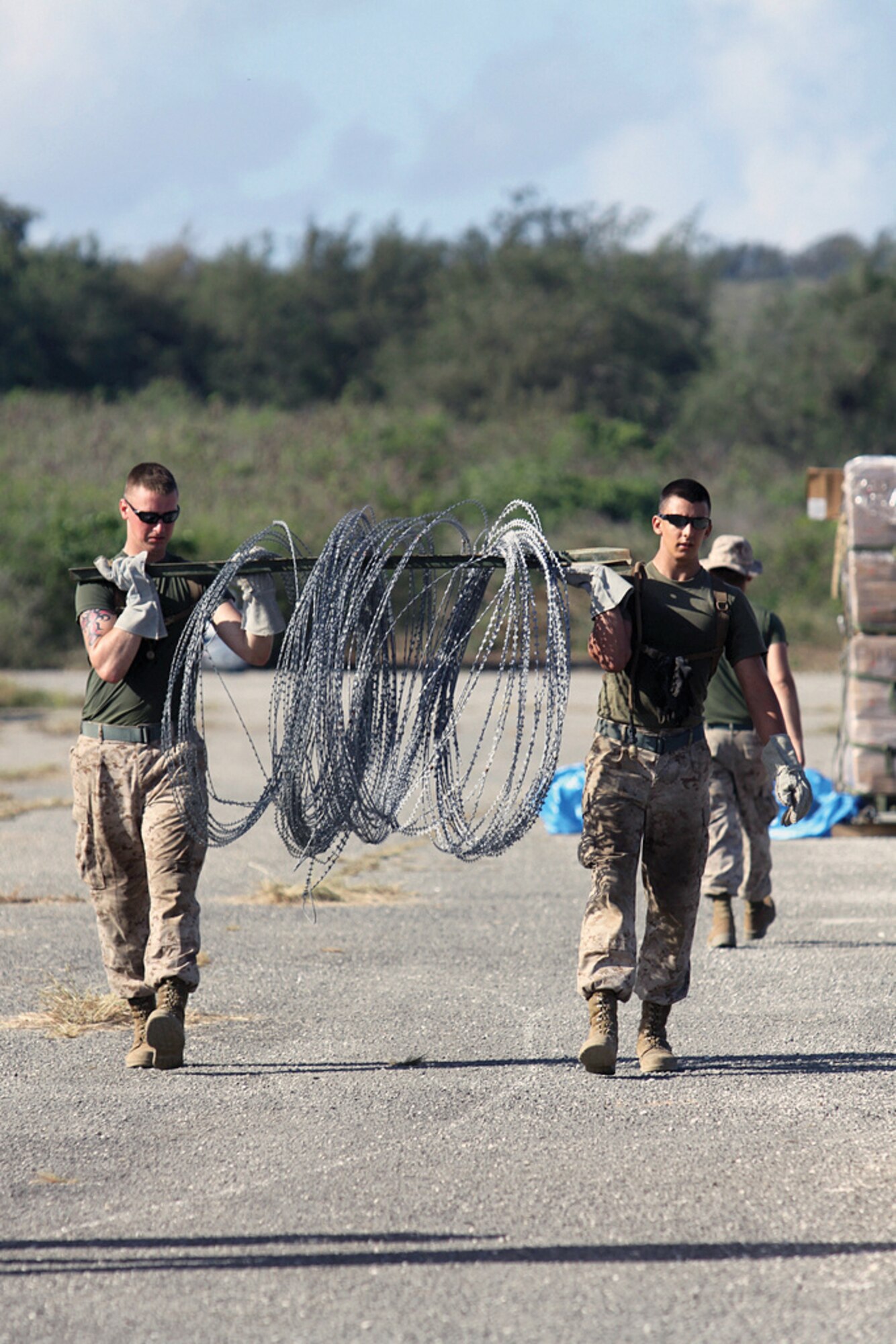 Marines move concertina wire while setting up an expeditionary airfield here May 15 during Exercise Geiger Fury 2012. The Marines made preparations to ensure training would go smoothly prior to the arrival of F/A-18 Hornets. The purpose of Geiger Fury is to increase operational readines and improve core expeditionary combat capabilities. The Marines are with Marine Wing Support Squadron 171, Marine Aircraft Group 12, 1st Marine Air Wing, III Marine Expeditionary Force. (U.S. Marine Corps photo/Lance Cpl. Gage Karwick/Released)