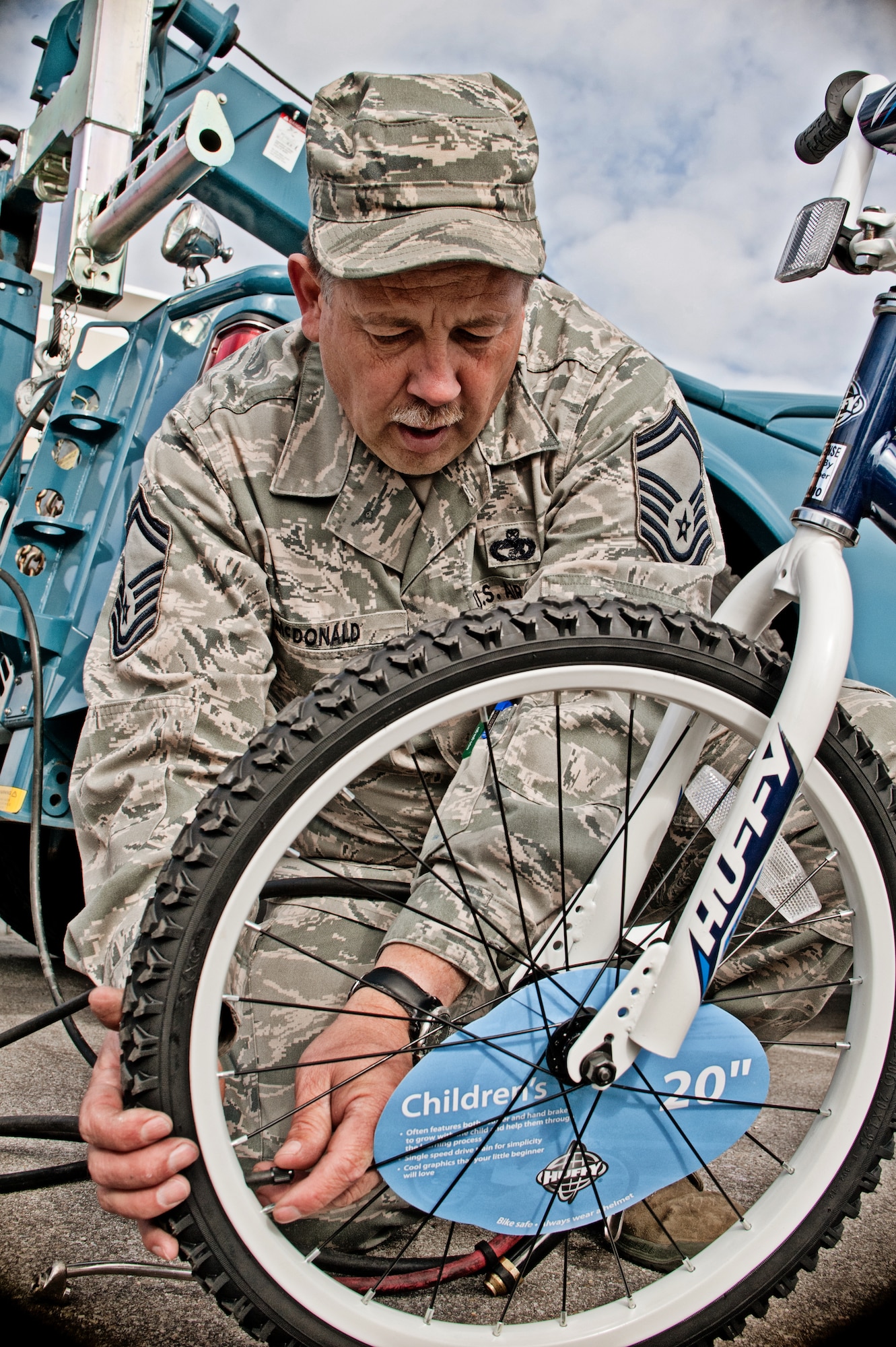 Senior Master Sgt. Robert McDonald, vehicle maintenance superintendent for the 124th Logistics Readiness Squadron, inflates the tires for a bicycle as part of Burgers for Bikes, Bikes for Kids, May 5, at Applebee's Restaurant on Vista Avenue in Boise. McDonald, who will retire this year after 32 years of service to Idaho and the nation, has volunteered for every one of the 20 Burgers for Bikes, Bikes for Kids events. (Air Force photo by Tech. Sgt. Becky Vanshur)