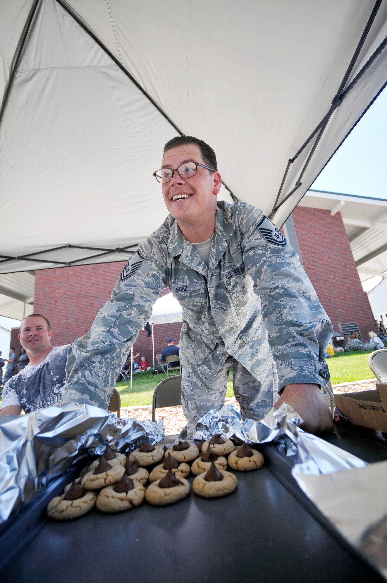 SSgt. Tim Smith looks on as MSgt. Ron Ford sells cookies at the 151st Air Refueling Wing's 2012 Airman Appreciation day at the Utah Air National Guard base in Salt Lake City Utah, June 2, 2012. (U.S. Air Force Photo by Tech. Sgt. Jeremy Giacoletto-Stegall/Released)